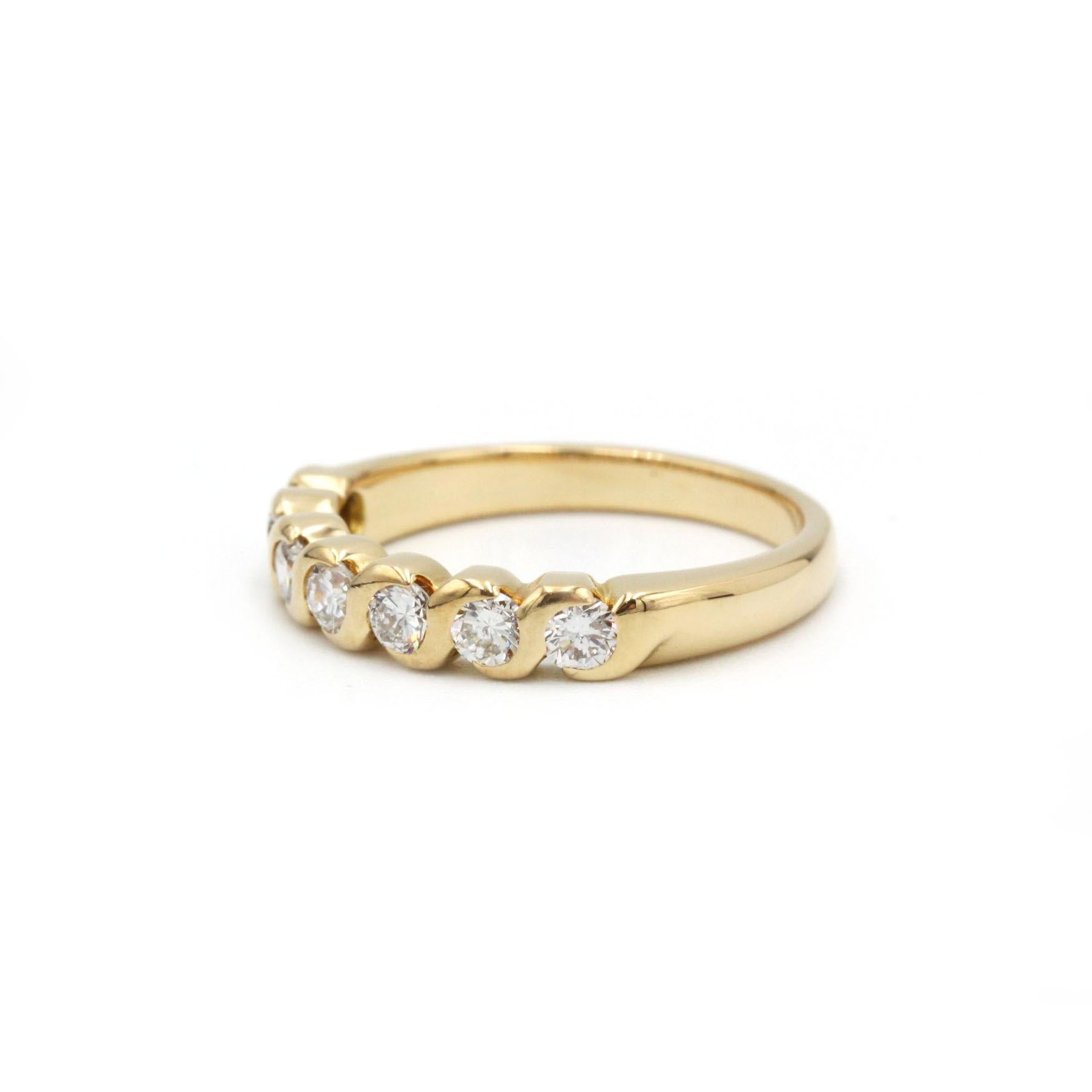Cette élégante bague française vintage de demi-éternité dégage un charme intemporel avec une touche de modernité. Réalisé en or jaune 18 carats, le bracelet présente un design torsadé sculptural qui maintient fermement sept diamants taille brillant.