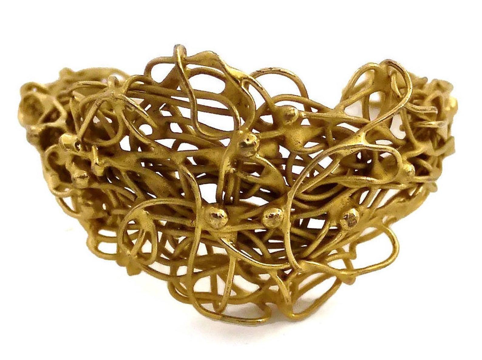 Vintage French Unsigned Knotted Coiled Wire Cuff Bracelet

Measurements:
Height: 1.6 inches (4 cm)
Inner Circumference: 7 inches (17.7 cm)

Features:
- Coiled and knotted wire pattern bracelet cuff.
- Gold tone.
- Unsigned piece (priced