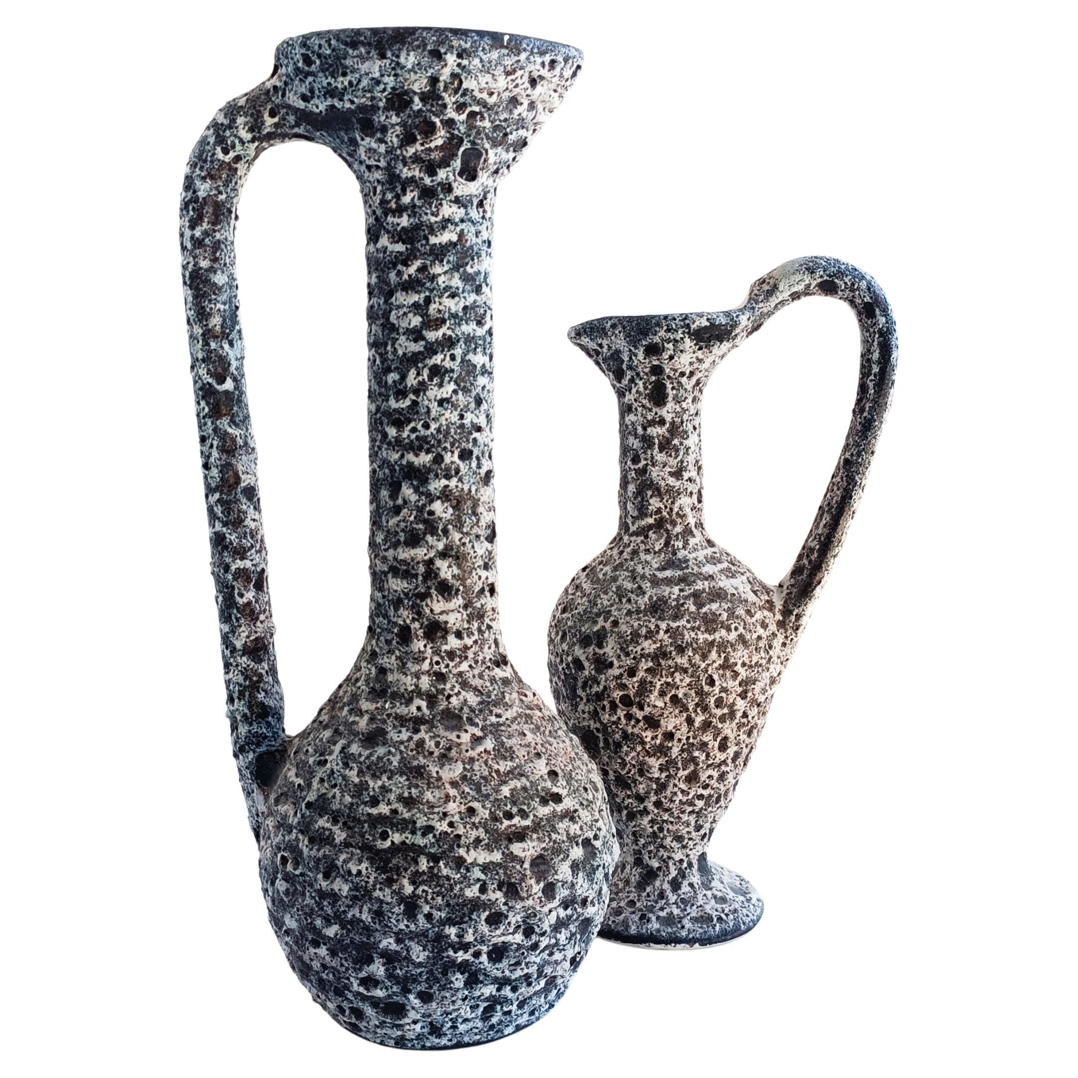 Stunning pair of large Brutalist Fat Lava decor fire burned glazing ceramic pitchers created by artist Alain Rufas and hand-produced in Vallauris, South France, circa the 1960s. 

Measurements:
Larger one
H. 40cm/ 16