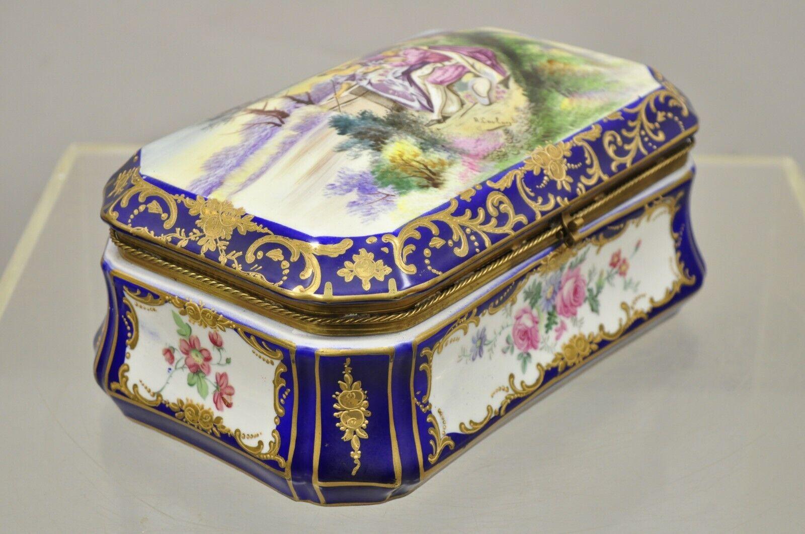 Vintage French Victorian blue porcelain hand painted hinged box signed R. Coulory. Item features hand painted floral details, hand painted interior, courting scene to lid, signed 