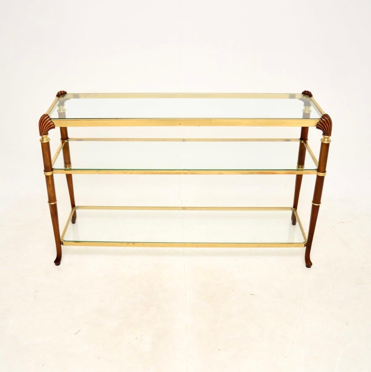An absolutely stunning vintage French walnut and brass console table, dating from around the 1960-70’s.

It is of superb quality, the solid walnut legs have gorgeous shell carving at the top corners. The brass finished frame supports three inset