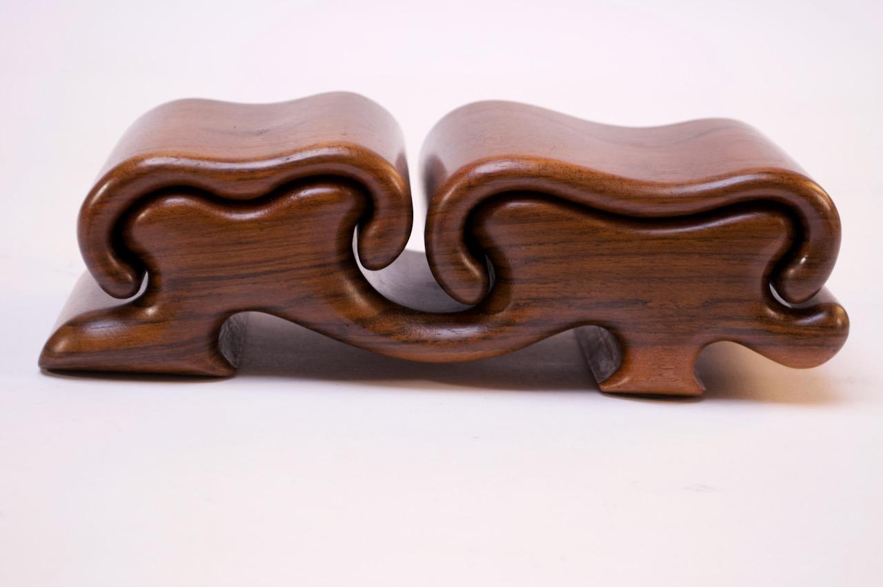 Dual-mushroom jewelry puzzle box by Fred Buss composed of solid French walnut components: two tops slide off (completely or partially) to reveal a dual-shallow, circular compartment for jewelry or other small items. 
Rich walnut color and exquisite