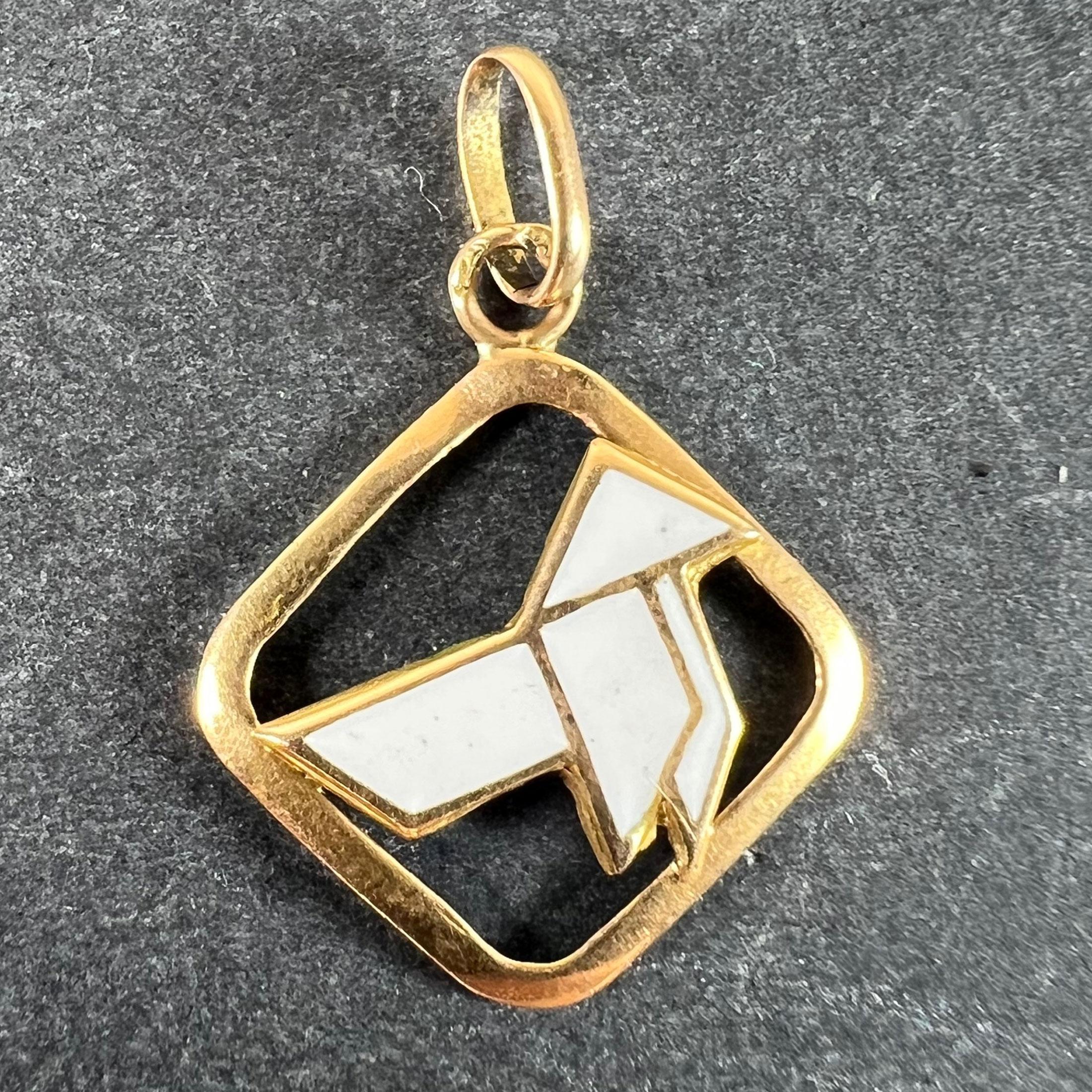 A vintage French 18 karat (18K) yellow gold charm pendant designed as a lucky white enamel origami bird in a diamond shaped frame. Stamped with the eagle's head mark for 18 karat gold and French manufacture with a partial unknown maker's