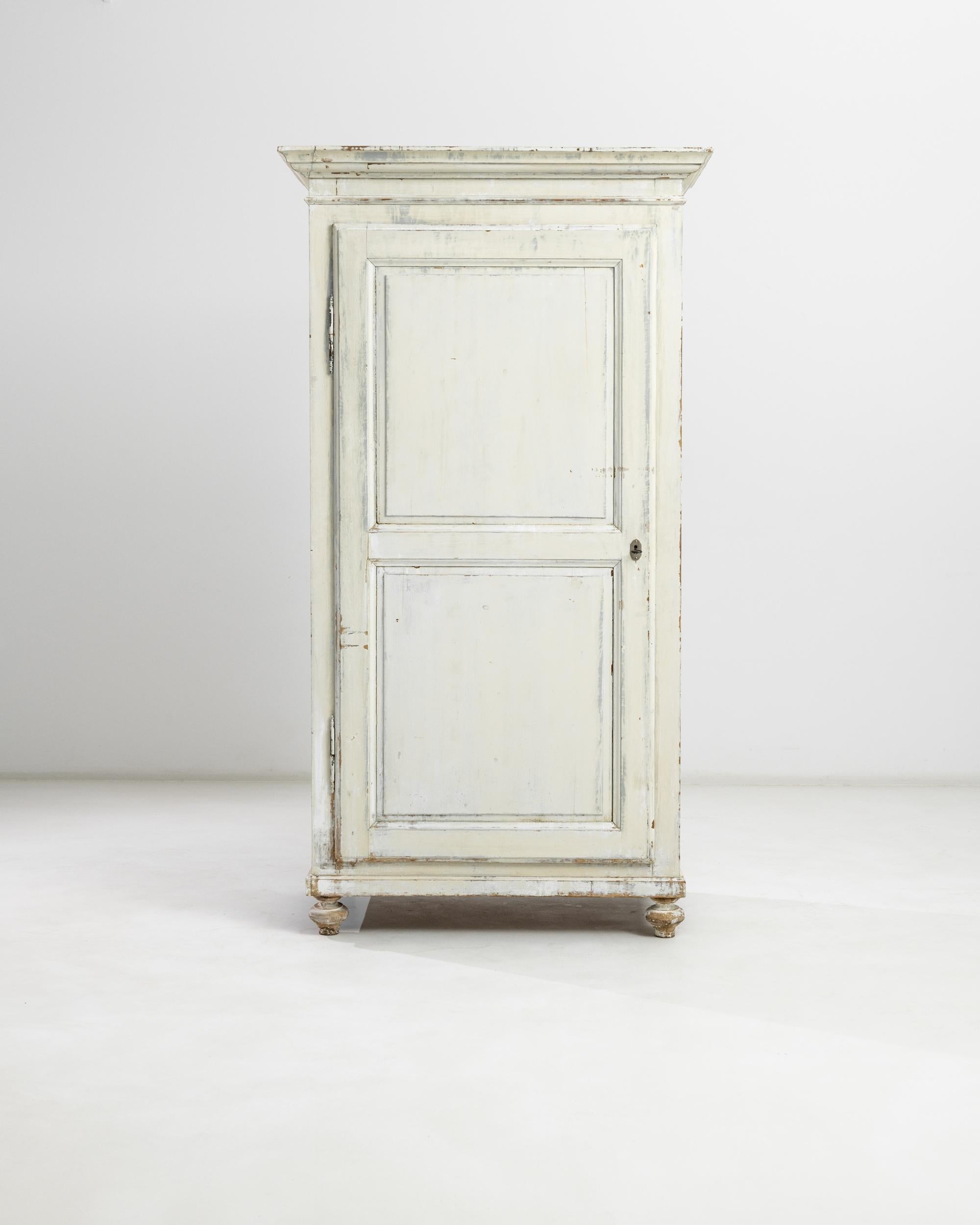 Sedate yet spirited, this charmful wooden cabinet from turn of the century France adds a romantic note to a space. A cyma recta molded cornice sits atop an upright case, elevated upon turnip feet. The picturesque silhouette is accentuated by the
