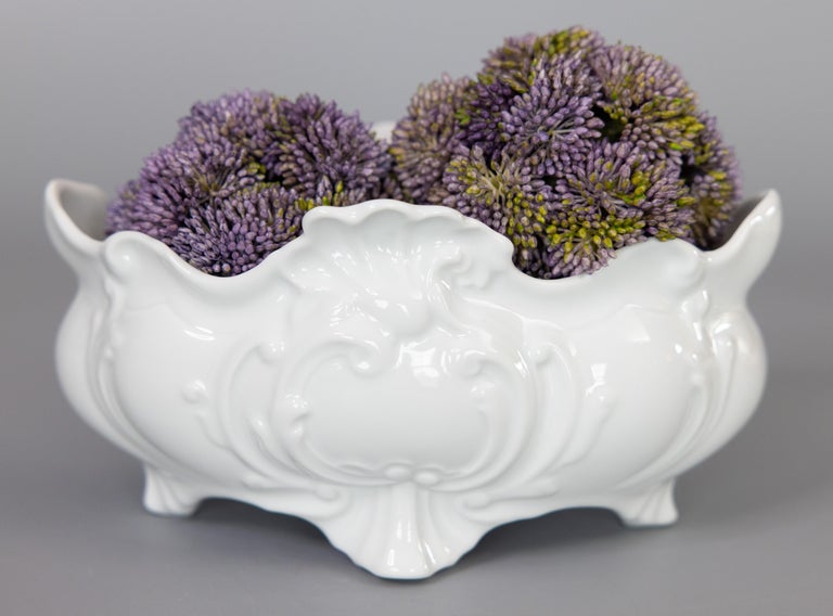A lovely vintage French white ironstone footed jardiniere / planter / cache pot. This beautiful planter has a scalloped rim and scrolls and shells motif in a timeless and classic Art Nouveau style. It would be perfect with your favorite plant or