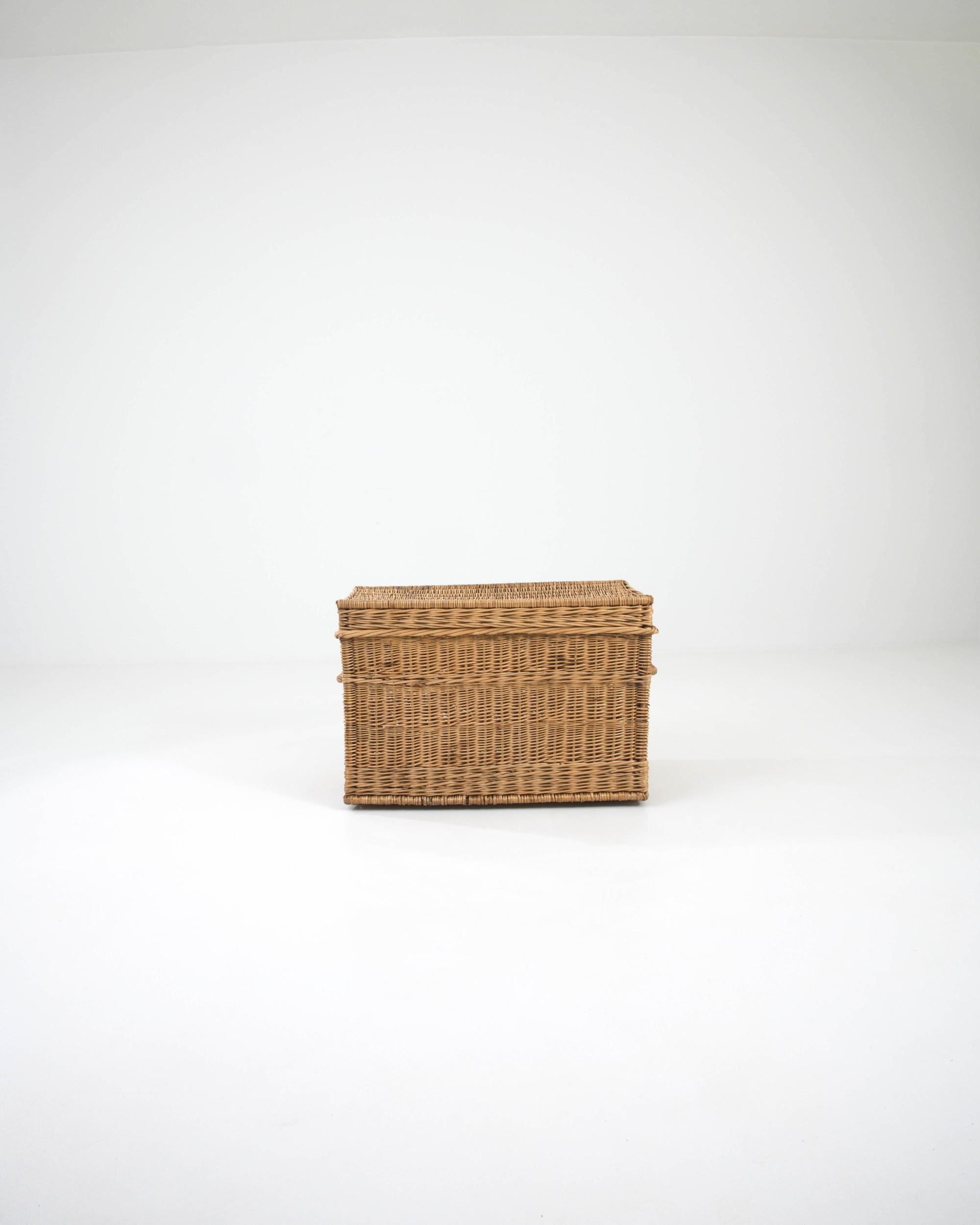 This charming and practical trunk is crafted from woven wicker, celebrated for its strength and flexibility. The intricate pattern serves both an aesthetic and functional purpose, enhancing the trunk's durability. The chest features a hinged lid