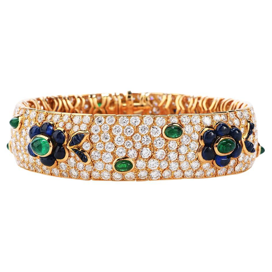 his French-made Diamond, Emerald , and Sapphire bracelet is sure to make a Statement in any room.

Wide throughout and flexible bangle bracelet, this 18k yellow gold bracelet has many links covered with Pave' set diamonds and flower patterns of