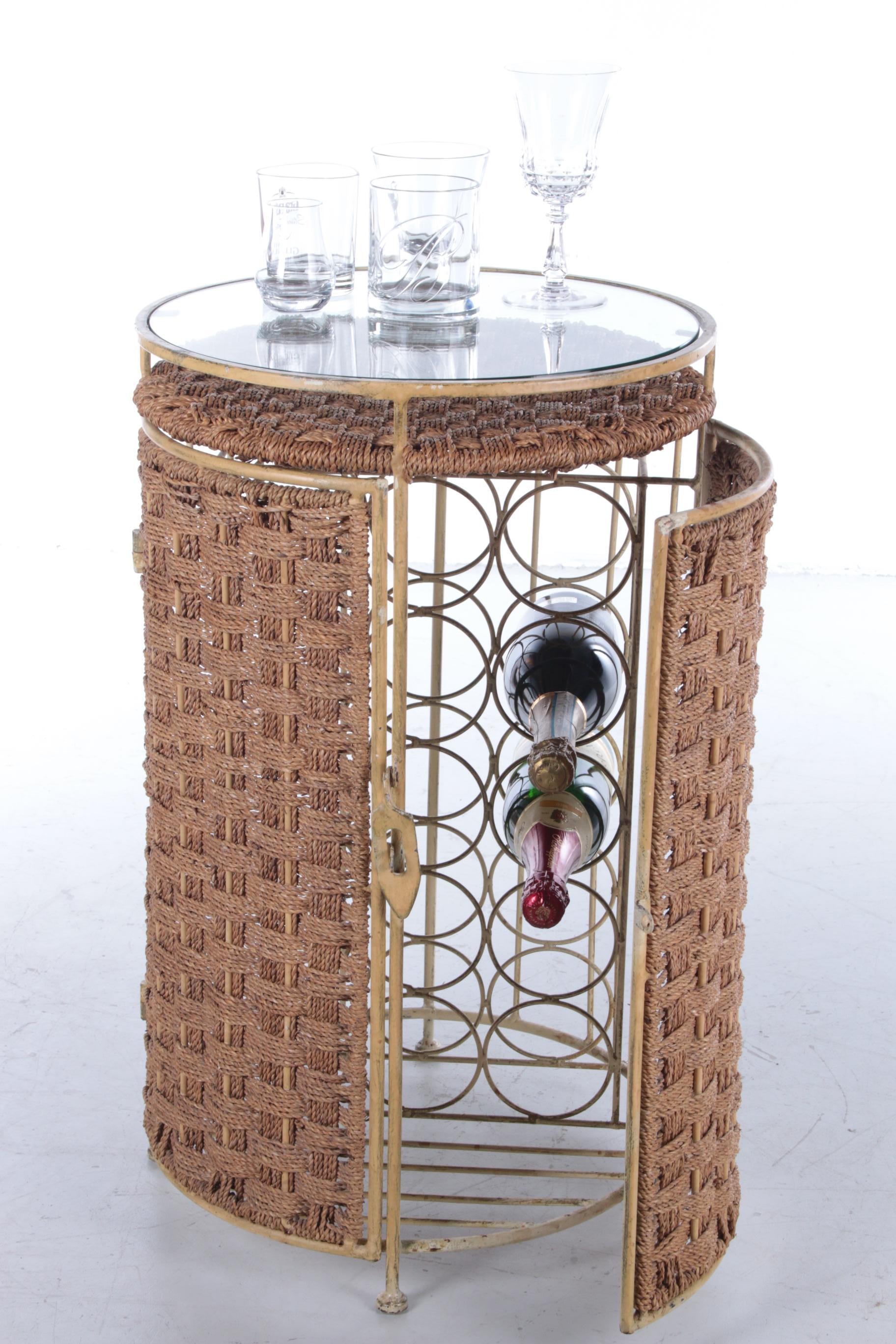 This is a very nice bottle rack from the South of France.

It is made in the 1960s from metal with sisal doors and a beautiful glass table top. This gives the bar a special and beautiful appearance whether the doors are open or closed.

The