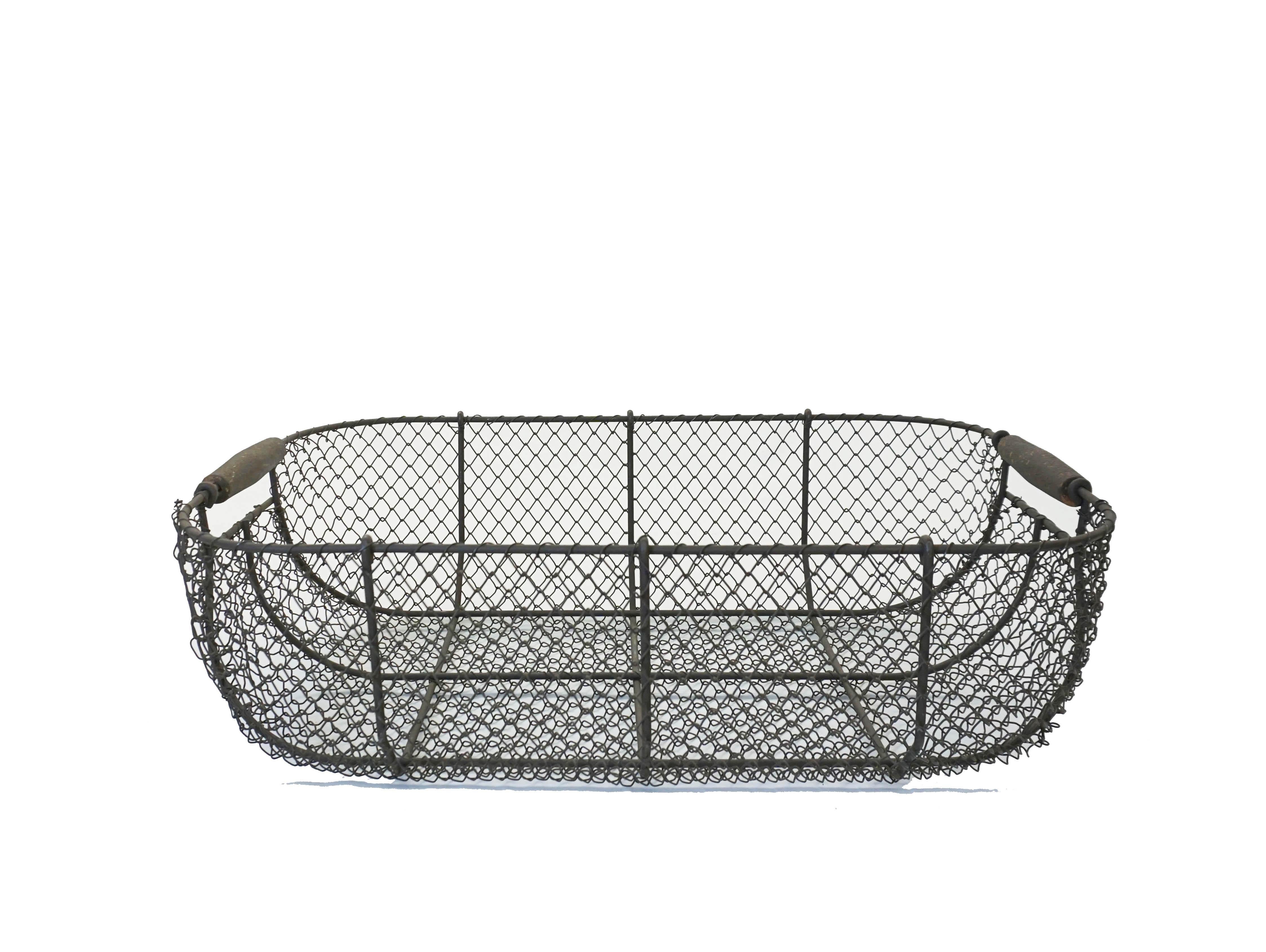 Large woven wire basket with rolled wood handles. This is a well crafted vintage piece from France in the mid 20th century. Use it as a table centerpiece or as a decorative item anywhere in the home.