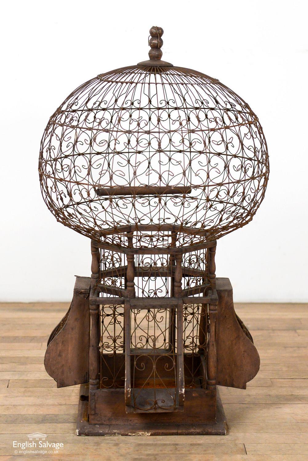Vintage archetypally French birdcage with beautiful detail. Made from wood and iron wirework, and has a slide-out drawer at the base for cleaning purposes. Overall measurements are given below and base measures: 40cm x 40cm. Age-related weathering