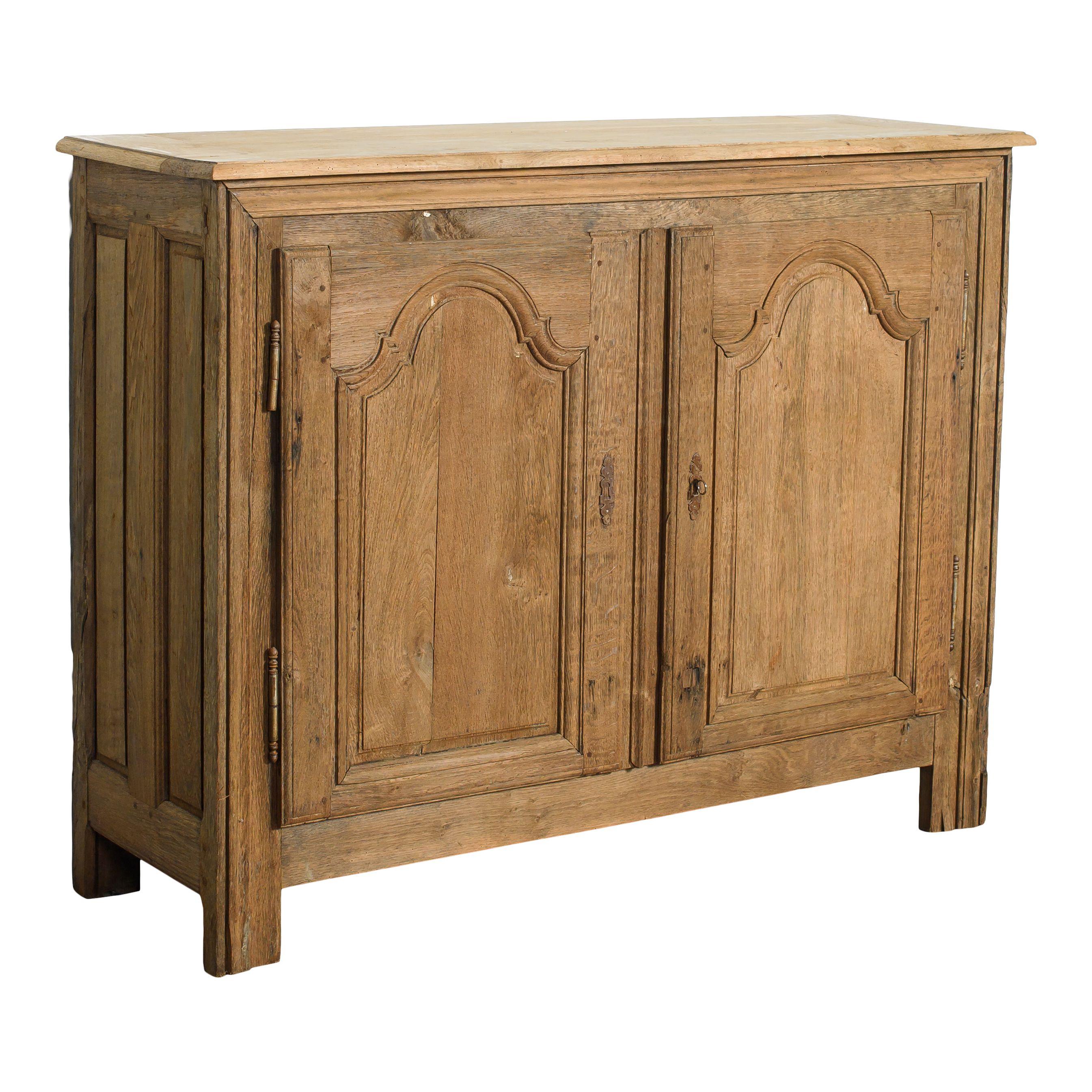 A classic vintage wood cabinet from France. This cabinet has a very classic and simple rectangle shape with small square legs. The two cabinet doors feature carved framing details and a small metal keyhole to open them with. The inside of the