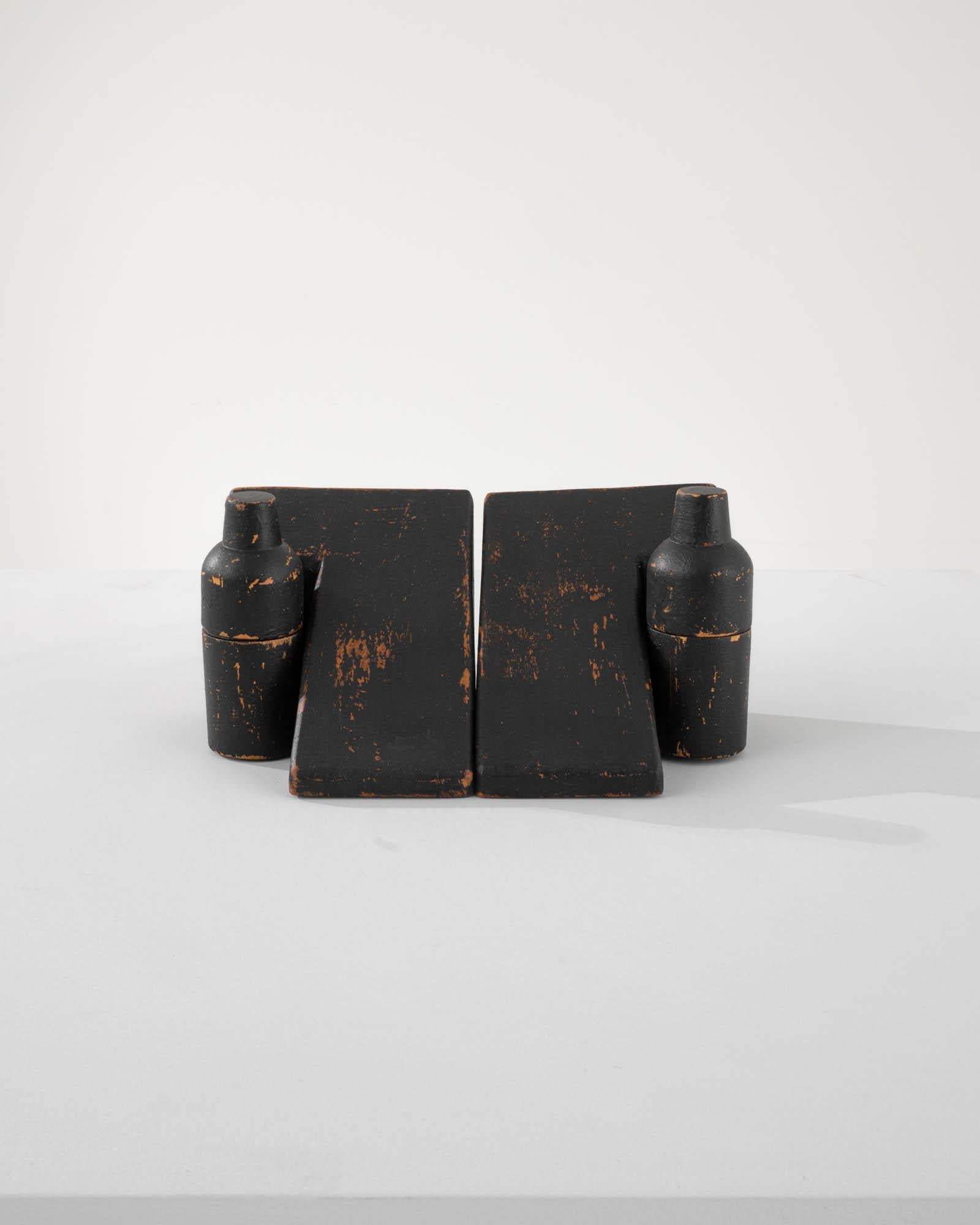 Diese originellen Buchstützen, die aus dem Frankreich des 20. Jahrhunderts stammen, zeigen eine fachmännische Schnitzerei in Form von glatten, L-förmigen geometrischen Figuren. Zusammen mit den flaschenartigen Holzbehältern bieten sie diskreten