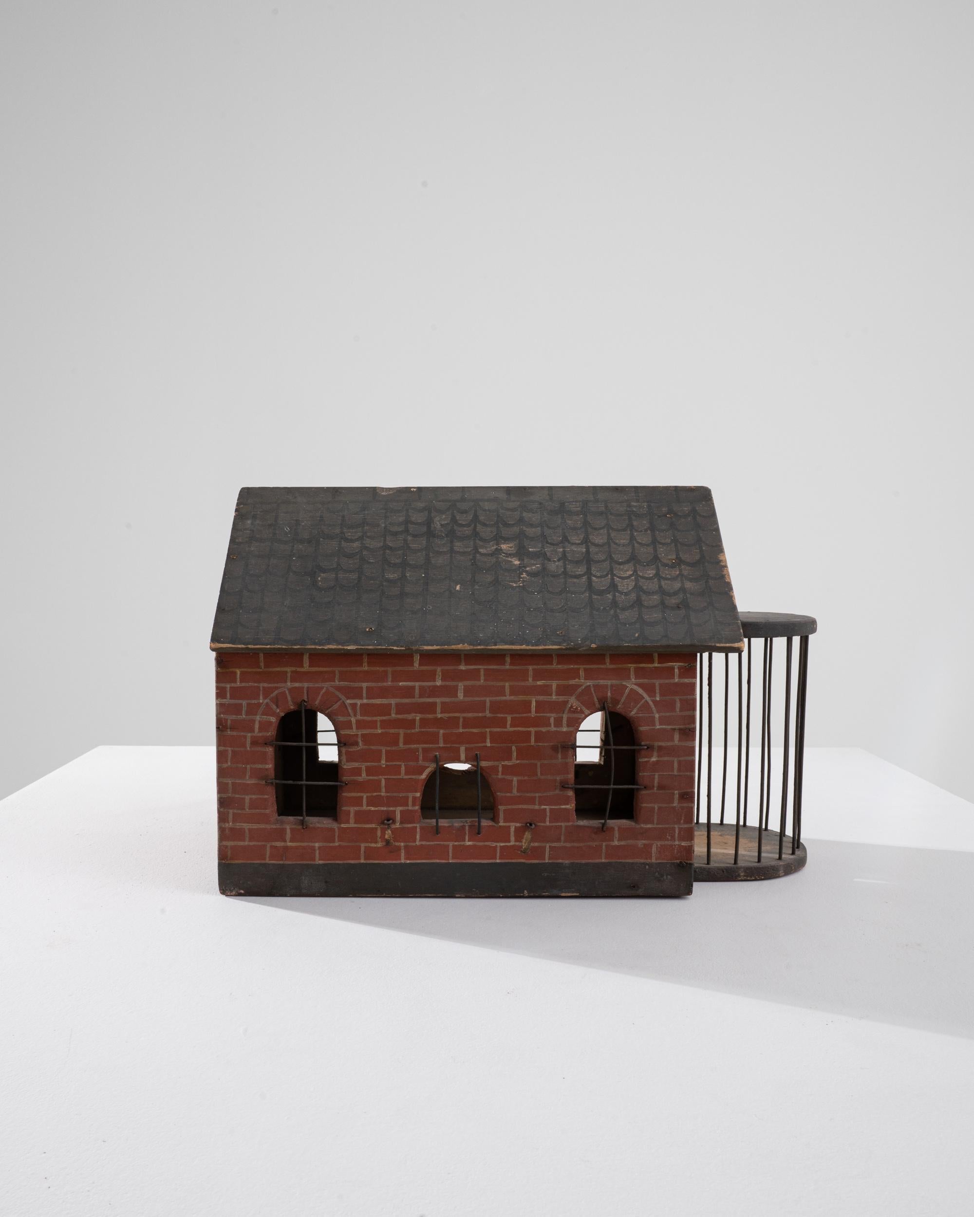 A wooden model made in early 20th century France. Puzzling in its purpose, but striking in its unique, hand-crafted character, this charming little building is sure to enliven the room in which it resides. Hand-painted brick walls and a tiled roof