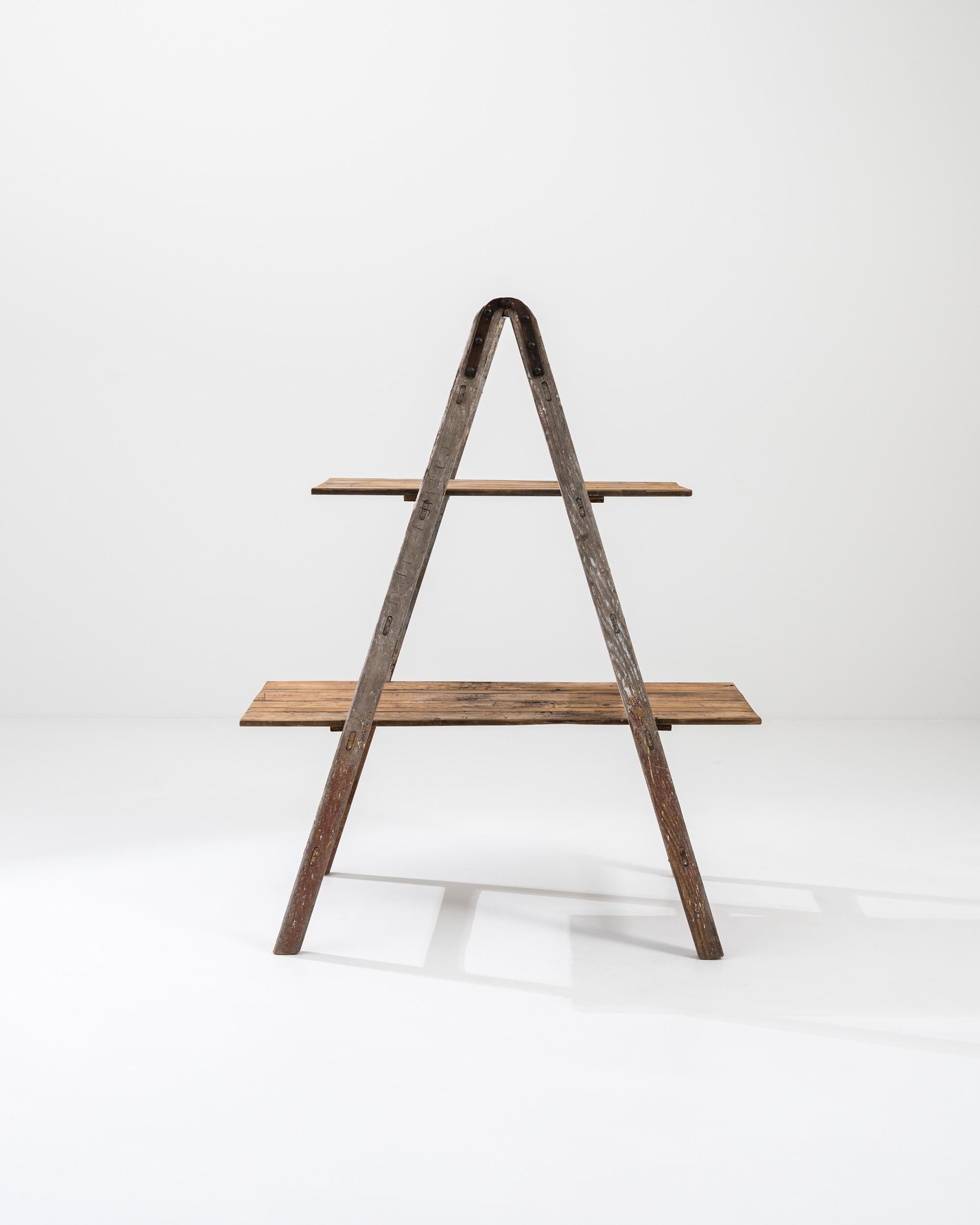 A vintage ladder from early 20th Century France, refigured into a two level shelving unit. Conjuring images of bricolage, this time-traveled object displays a nostalgic patina; scuffs and dings, drips of paint record the telltale stories of projects