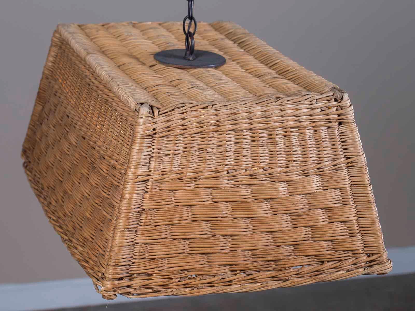 An unusual vintage French woven basket chandelier from France circa 1920 converted into a custom modern light fixture. This essential component of French life, the rectangular woven basket, is in excellent condition with its wooden frame providing a