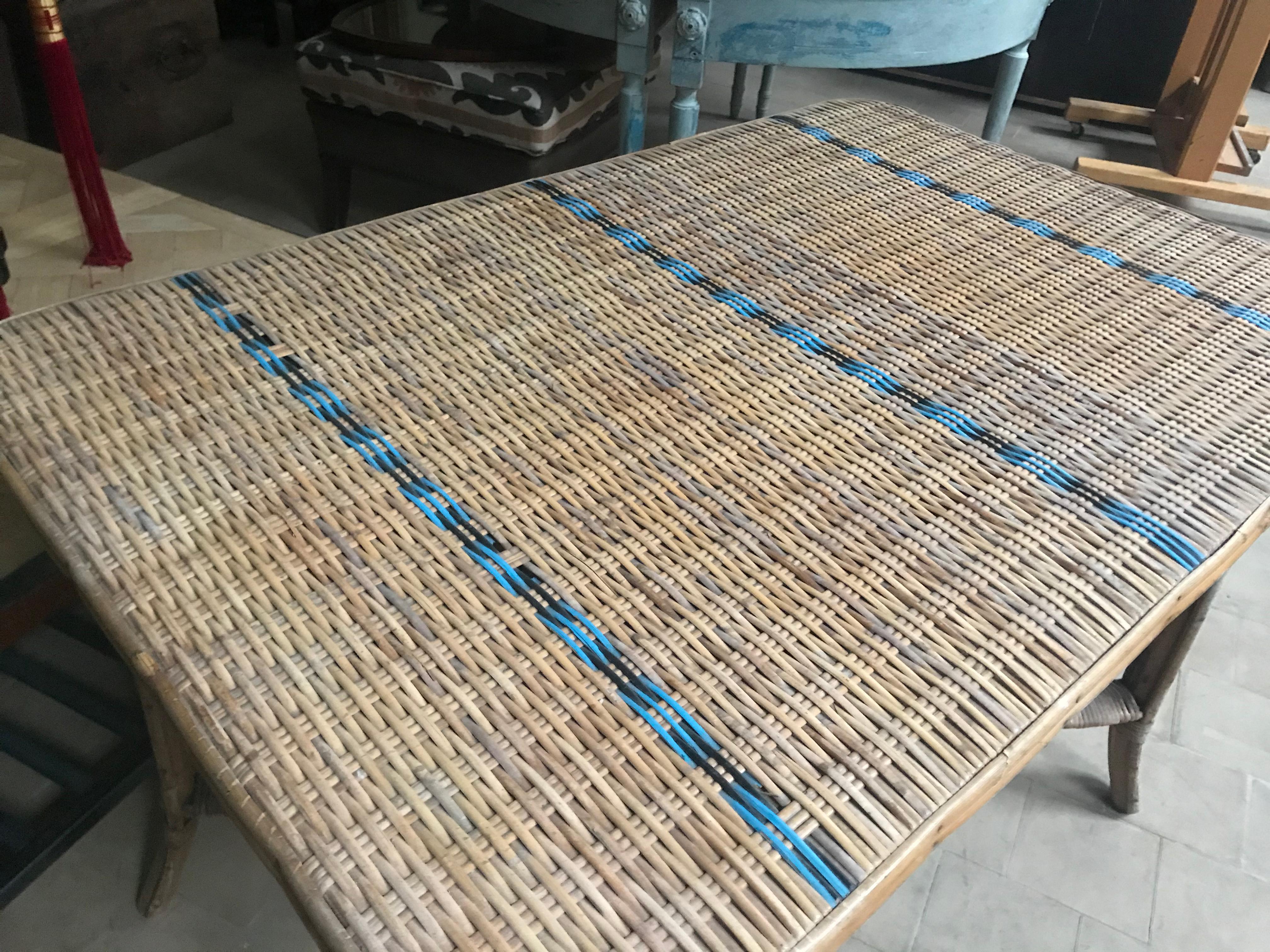 A vintage circa 1920 French woven rattan table. Woven in natural split reed with blue painted reed stripes. Exceptional craftsmanship and design, having a sturdy bamboo frame with x-pattern stretcher and tightly woven tabletop.