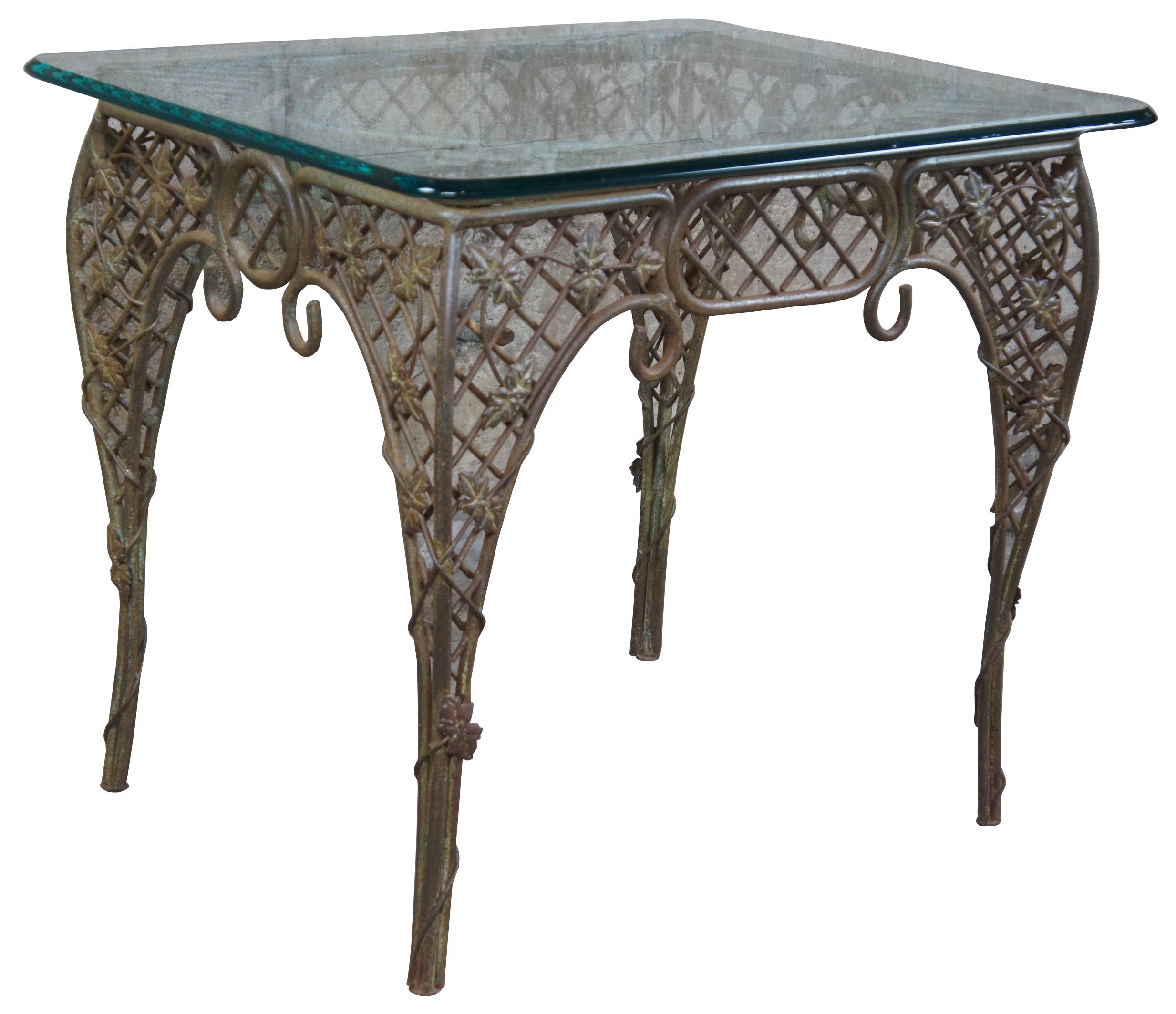 Heavy wrought iron French outdoor parlor table. Features a lattice network with maple leaves and scrolled accents and glass top.
 