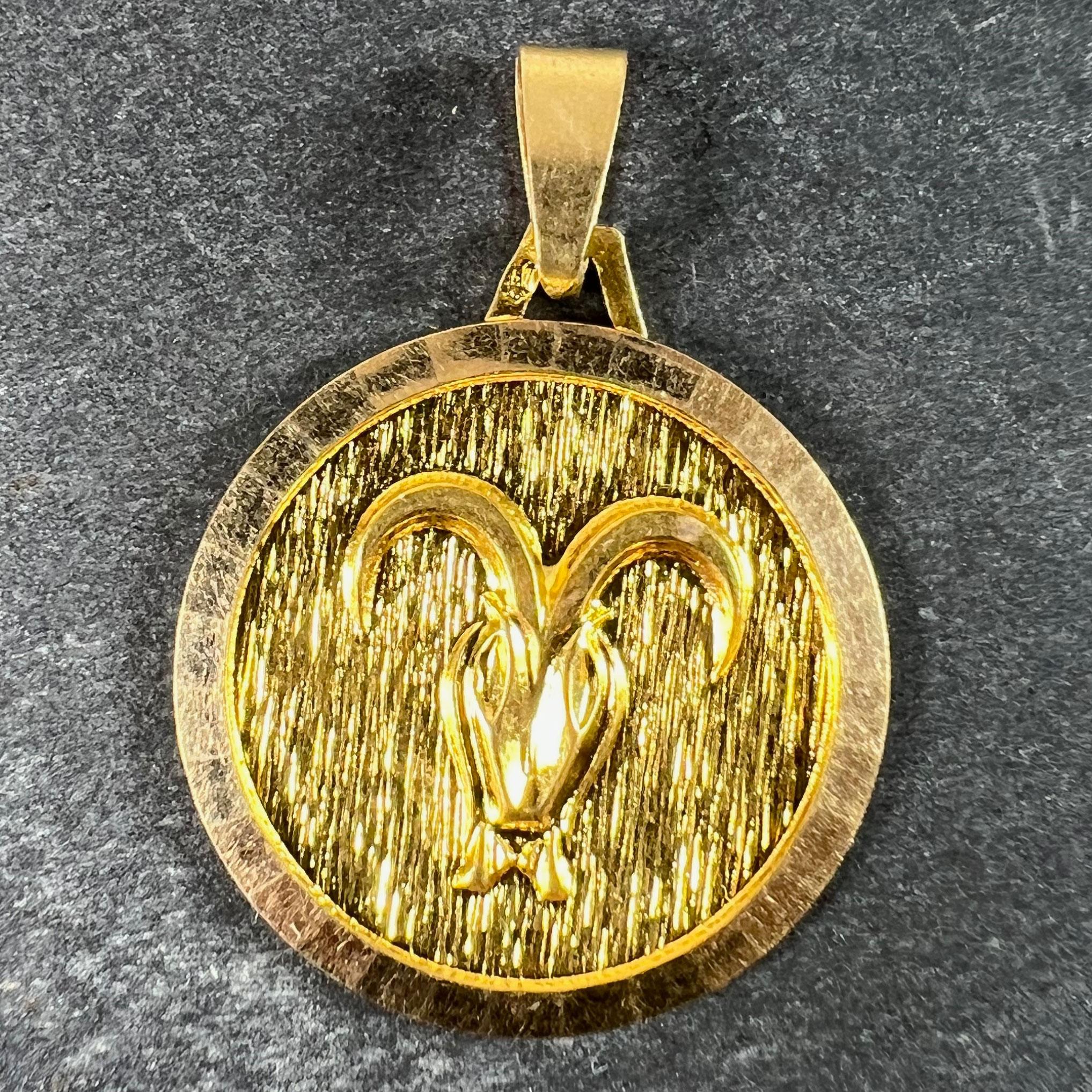 Un ciondolo vintage francese in oro giallo 18 carati (18K), disegnato come il segno zodiacale di Ares in oro giallo all'interno di una cornice circolare, che raffigura un ariete dal davanti, con le corna che formano la forma del simbolo del segno