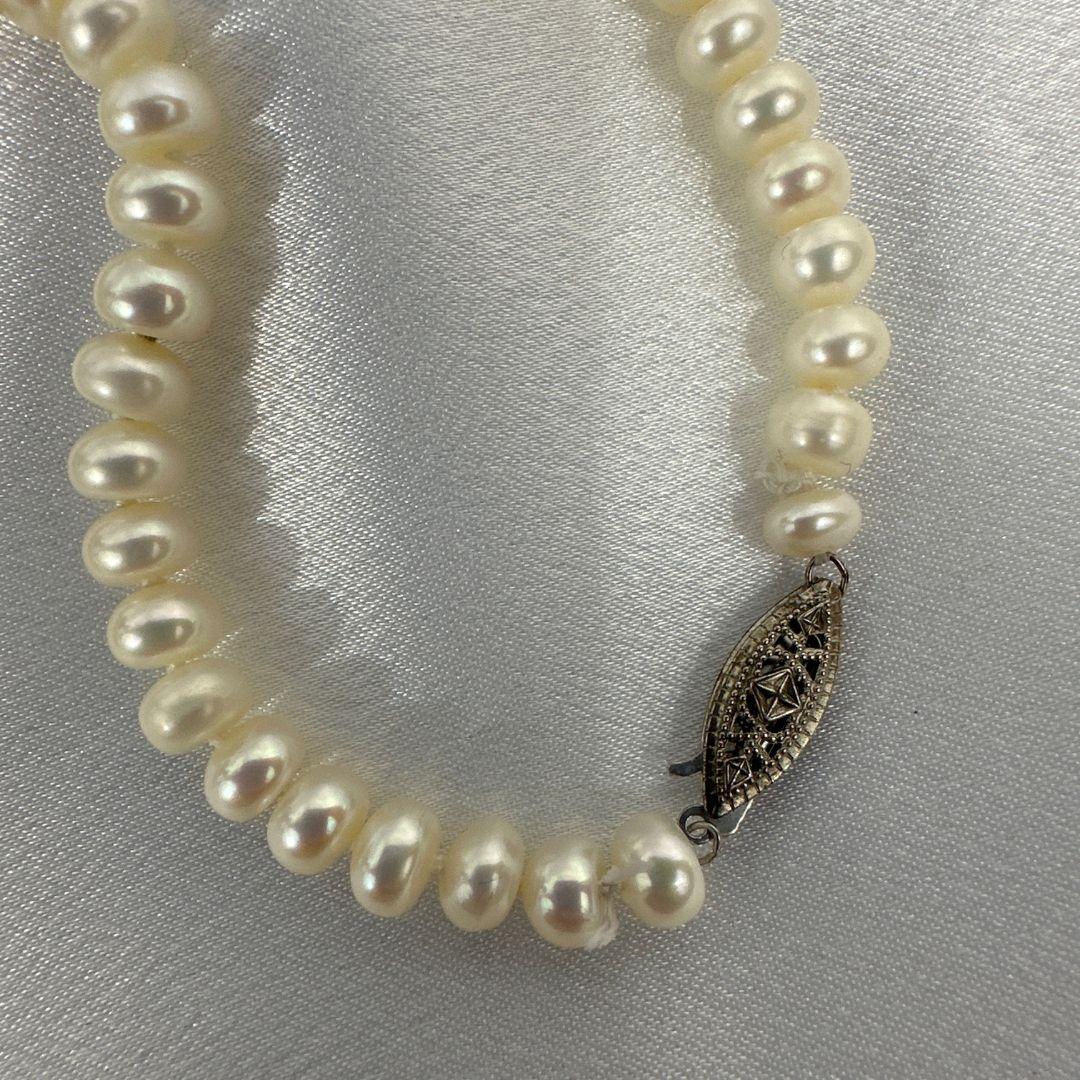 Lassen Sie sich vom zeitlosen Charme dieser Vintage-Süßwasserperlenkette mit Perlen verzaubern. Diese mit glänzenden Perlen besetzte Halskette strahlt klassische Eleganz und Raffinesse aus. Die natürlichen Perlen, jede einzigartig in ihrer
