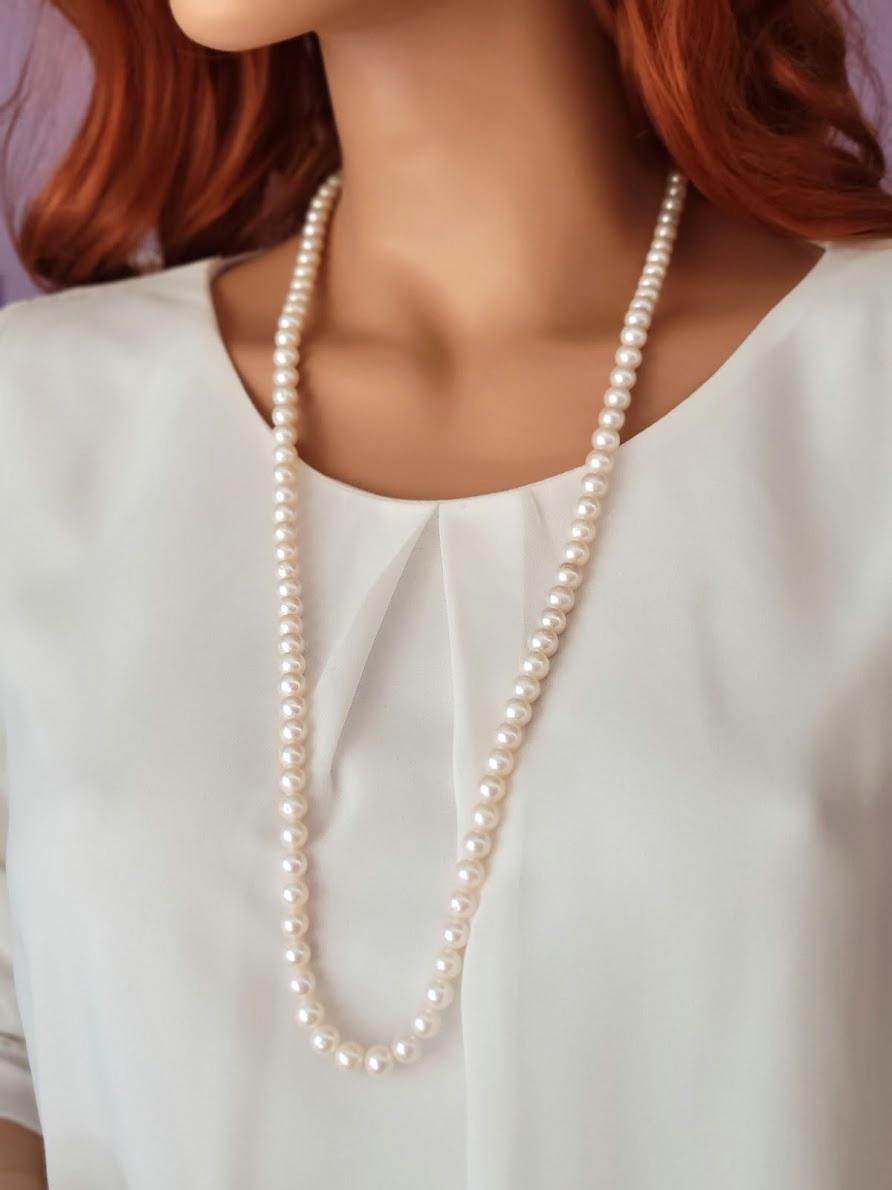 The Freshwater cultured pearls exude a lustrous allure. 
The length of the necklace is 33 inches (84 cm). The size of the smooth round beads is 7 mm.
The necklace is finished with a decorative 14k gold clasp with a natural freshwater pearl. This