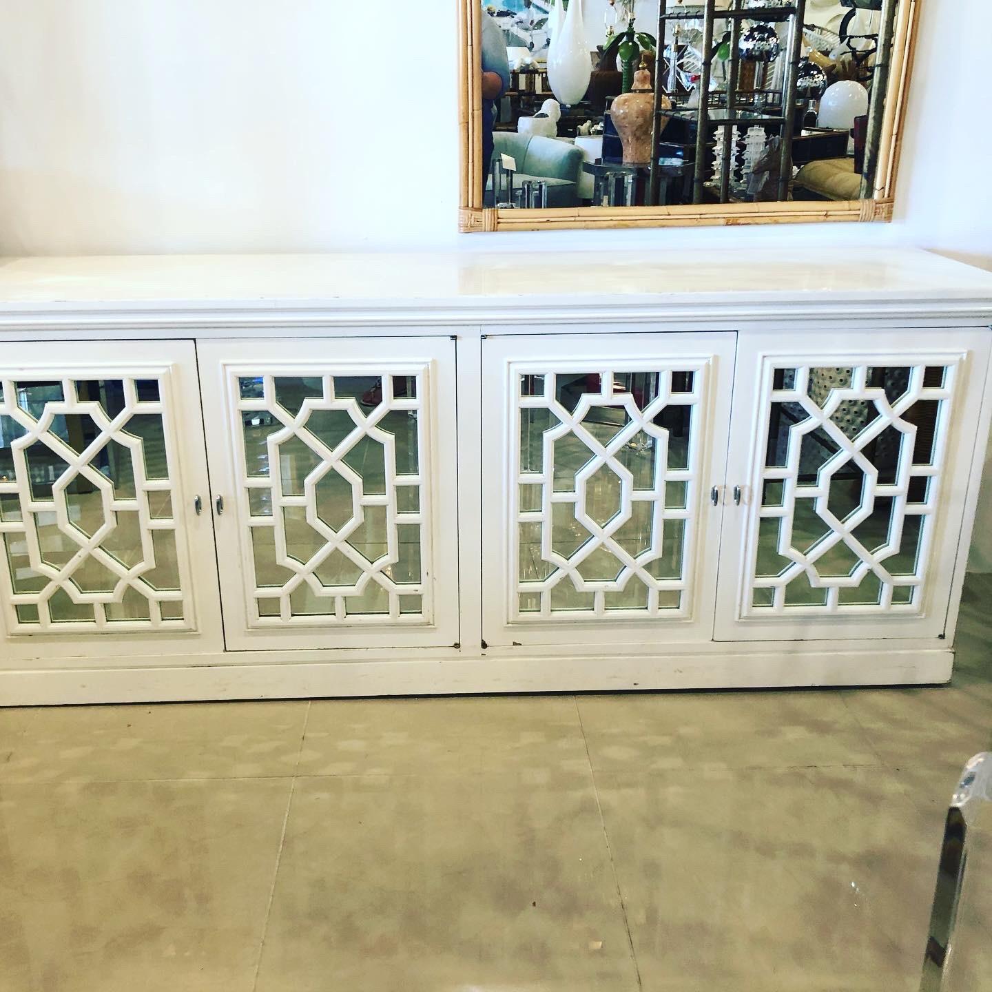 Vintage fretwork credenza with mirrored Chinese Chippendale doors that open up to reveal two adjustable shelves on each side. Original white vintage finish will need to be lacquered as there is scuffs and chips to finish. Can be lacquered at an