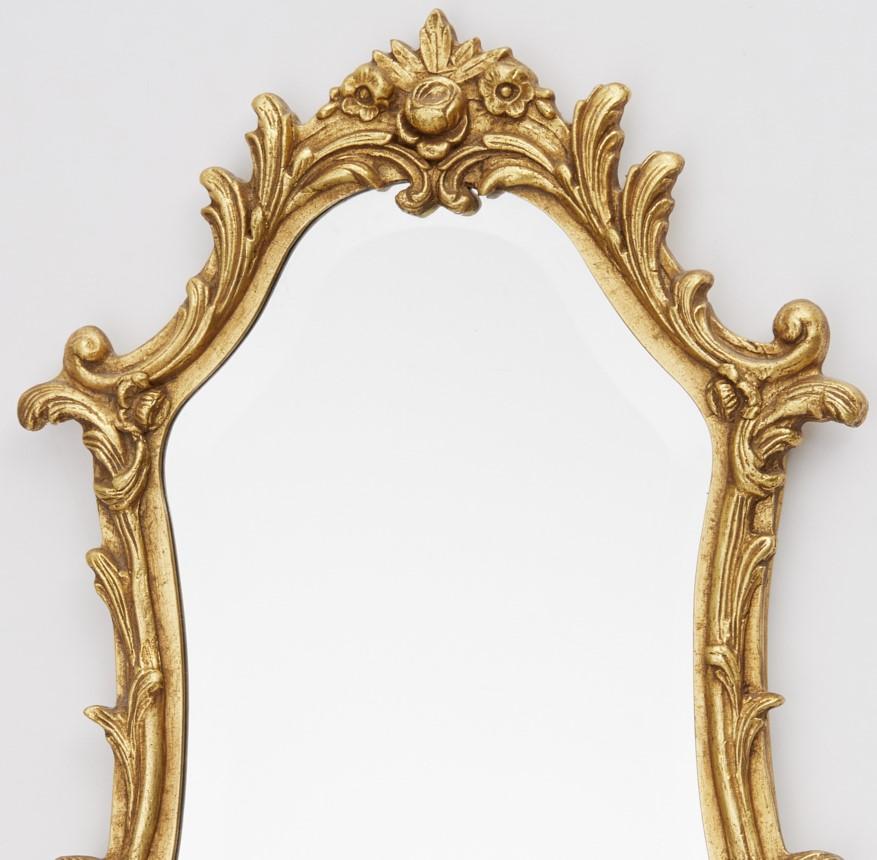 20th c., scrolled flower frame design with beveled glass, Friedman Brothers sticker label verso. A beautiful mirror with just the right touch of ornamentation, it would look wonderful in a powder room. 

Per their site, 