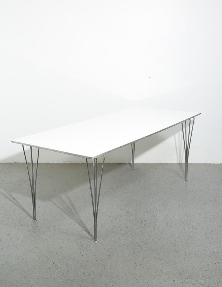 Vintage 'Span Leg' dining table designed by Piet Hein, Bruno Mathsson, and Arne Jacobsen for Fritz Hansen. Flexible steel rod table legs are designed for almost instant removal and install. Top is a gloss white laminate with a satin aluminum