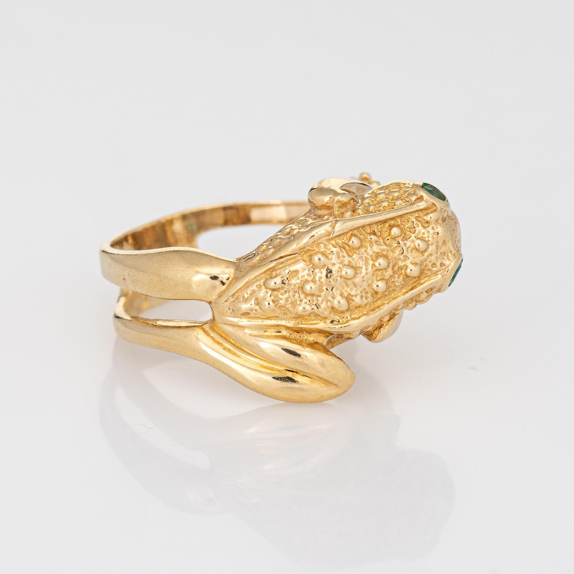 Stylish vintage frog ring (circa 1970s to 1980s) crafted in 14 karat yellow gold. 

Two estimated 0.03 carat emeralds are set into the eyes (0.06 carats total estimated weight). 

The finely detailed frog features textured detail to the back,