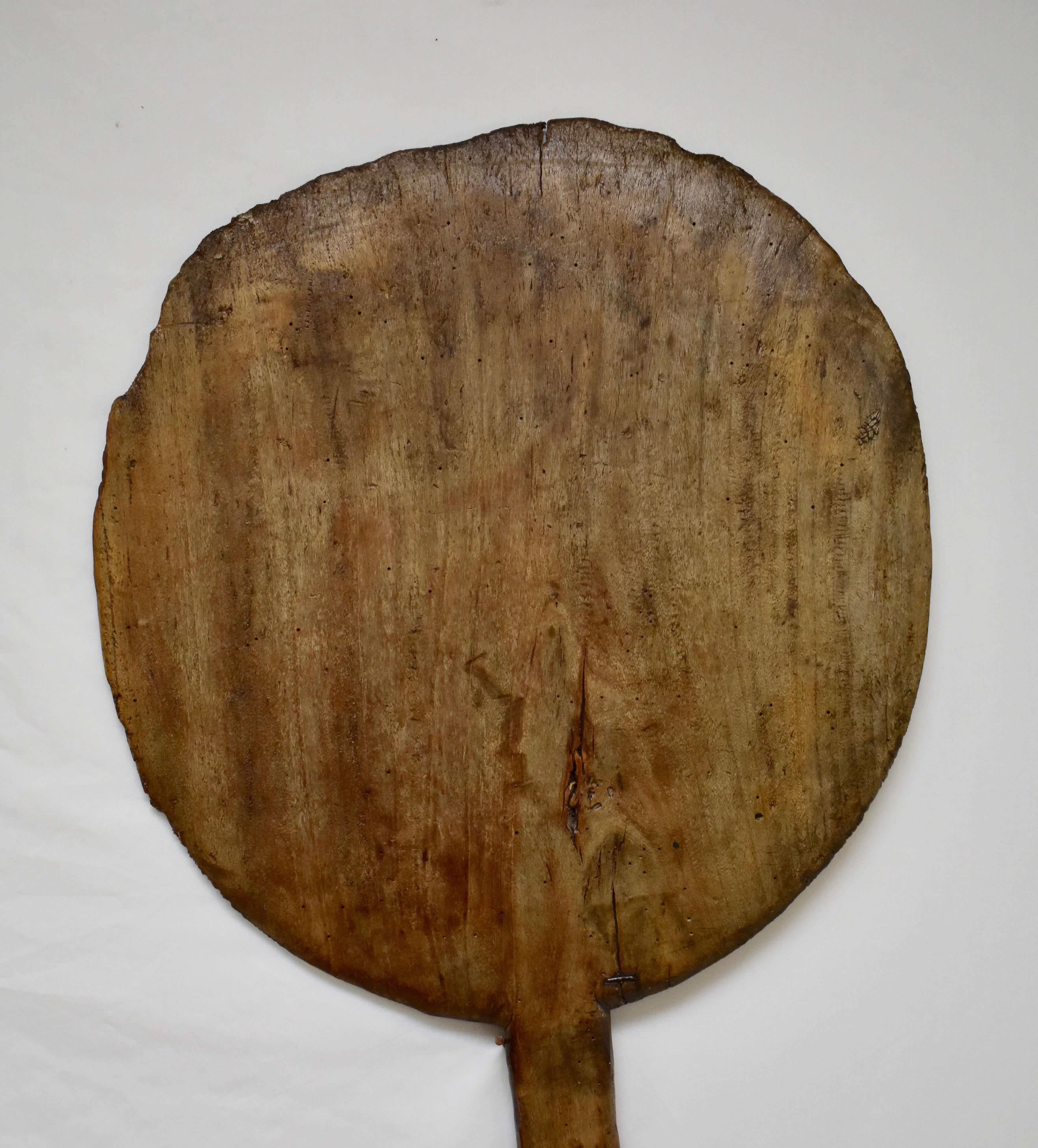 Much lighter in weight than its oak counterparts, this vintage fruitwood bread peel is also hand-carved from a single board. The wide shaft is worn smooth and the paddle has minor chips to the lip with a nice stapled repair near the shaft end.