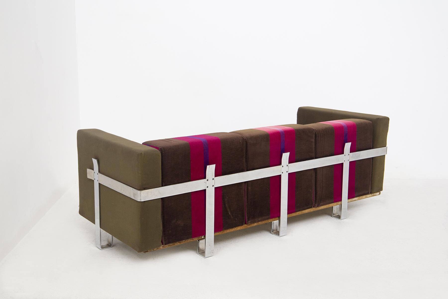 Das wunderschöne Sofa aus Stoff, entworfen von Luigi Caccia Dominioni für den feinen Hersteller Azucena Italia.
Das Vintage-Sofa ist aus braunem, fuchsiafarbenem und lila gestreiftem Stoff gefertigt, der einen sehr bunten geometrischen Effekt