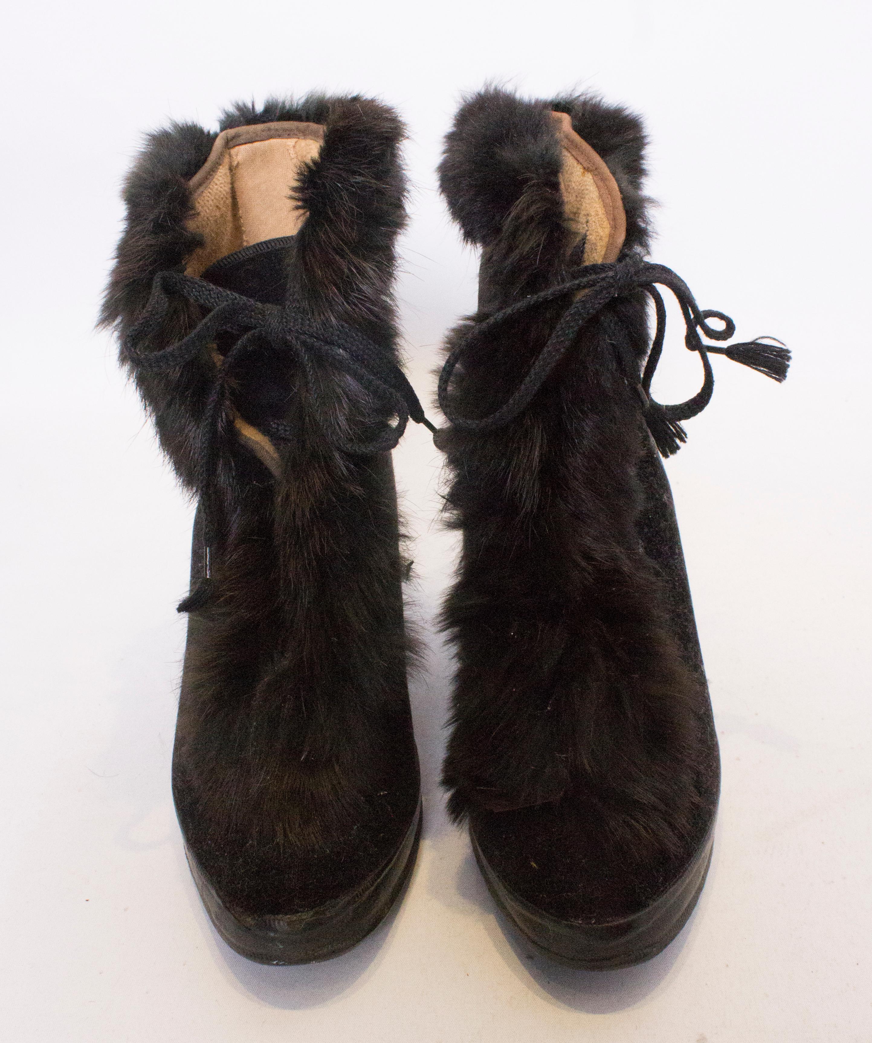 An unusual pair of fur trimmed over shoes. These are great for wearing with you evening shoes as the heel is hollow . Best size for a UK 5 1/2 - 6 1/2,.