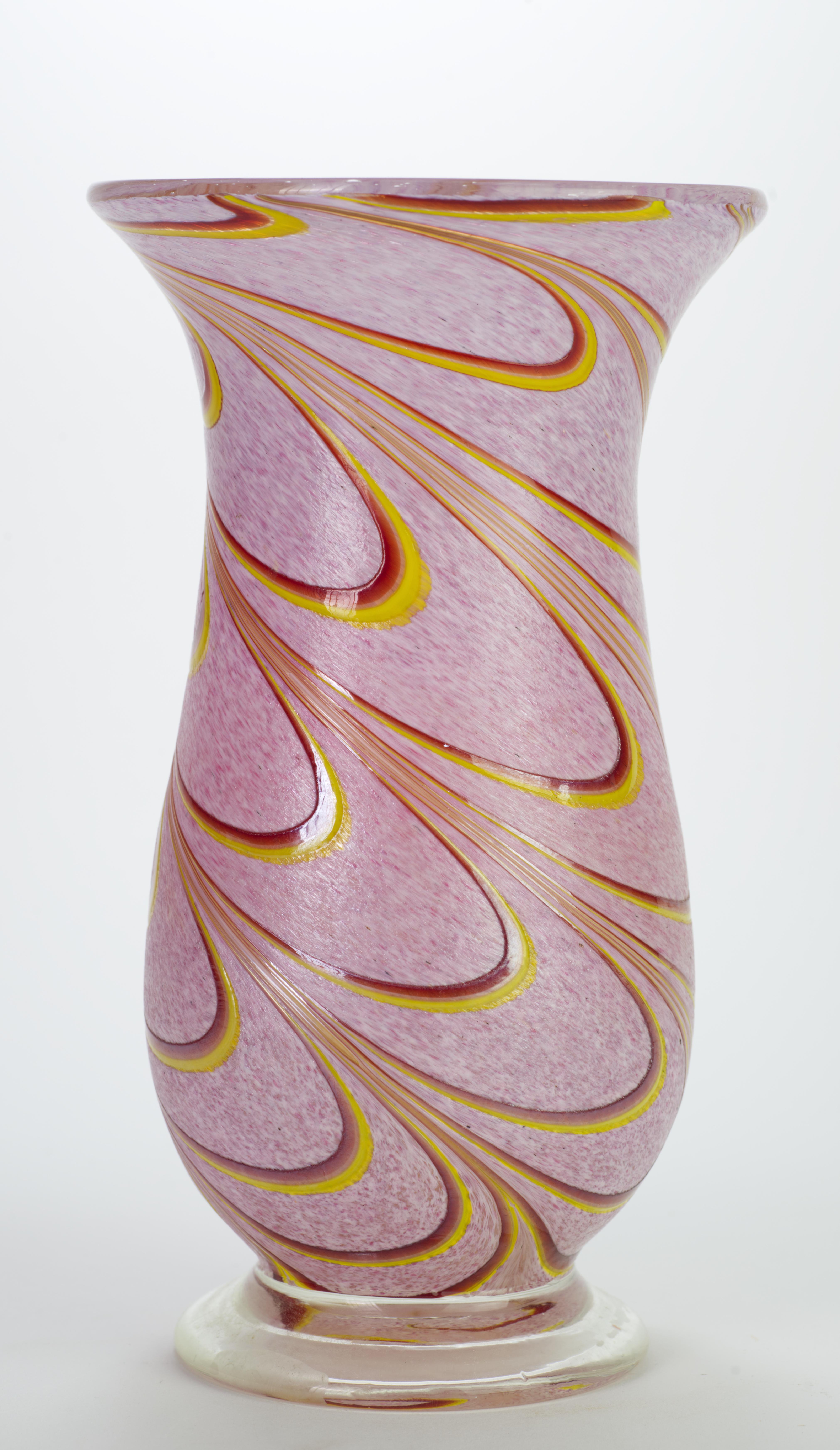  Sculptural vintage vase is decorated with free-flowing fused red and yellow glass designs on mottled pink glass background; colored glass encases clear glass core, with clear glass foot that adds height and separation to the piece. Ground pontil on