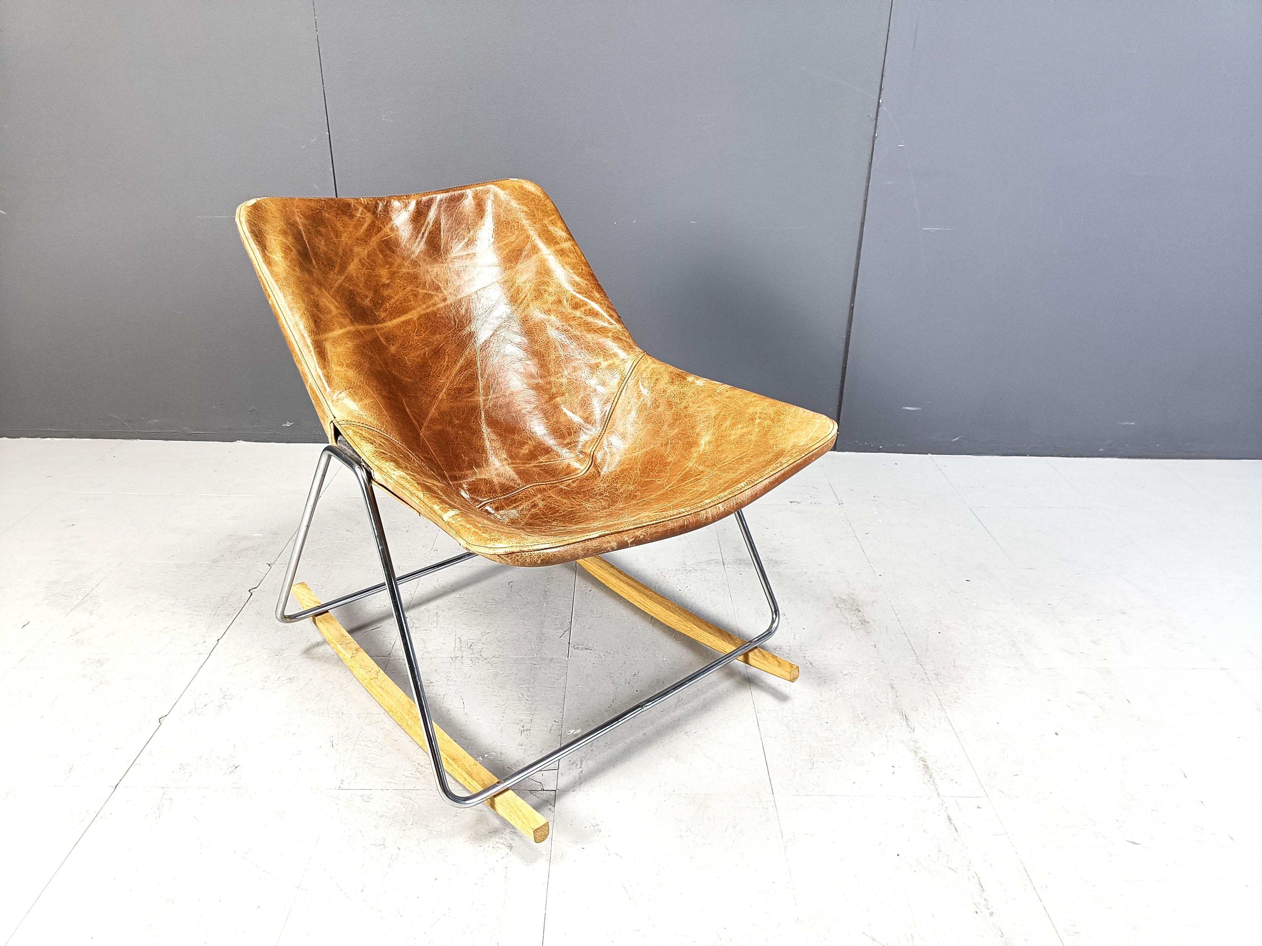 Mid century rocking chair model 'G1' designed by Pierre Guariche for Meurop.

Camel leather upholstery on a chromed metal frame and wooden feet.

1950s - France/Belgium

Designed in the 1950s 

Beautiful condition

Dimensions:
Height: 73cm 
Width: