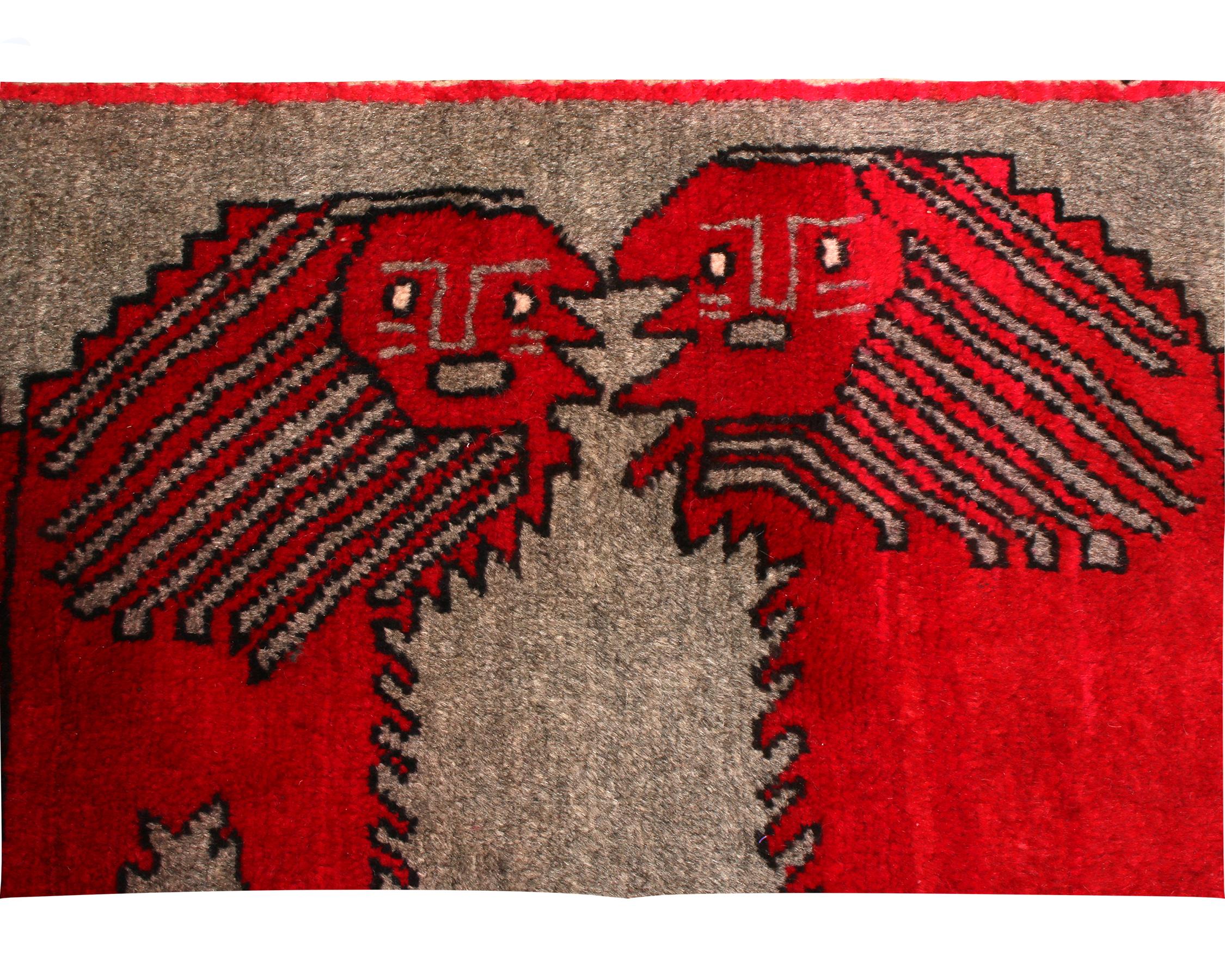 Hand knotted in wool pile originating from Persia between 1950-1960, this vintage Gabbeh Persian rug is unique among the acclaimed pictorial pieces of its family for enjoying a minimalistic, more dignified background over the abundantly wild, tribal