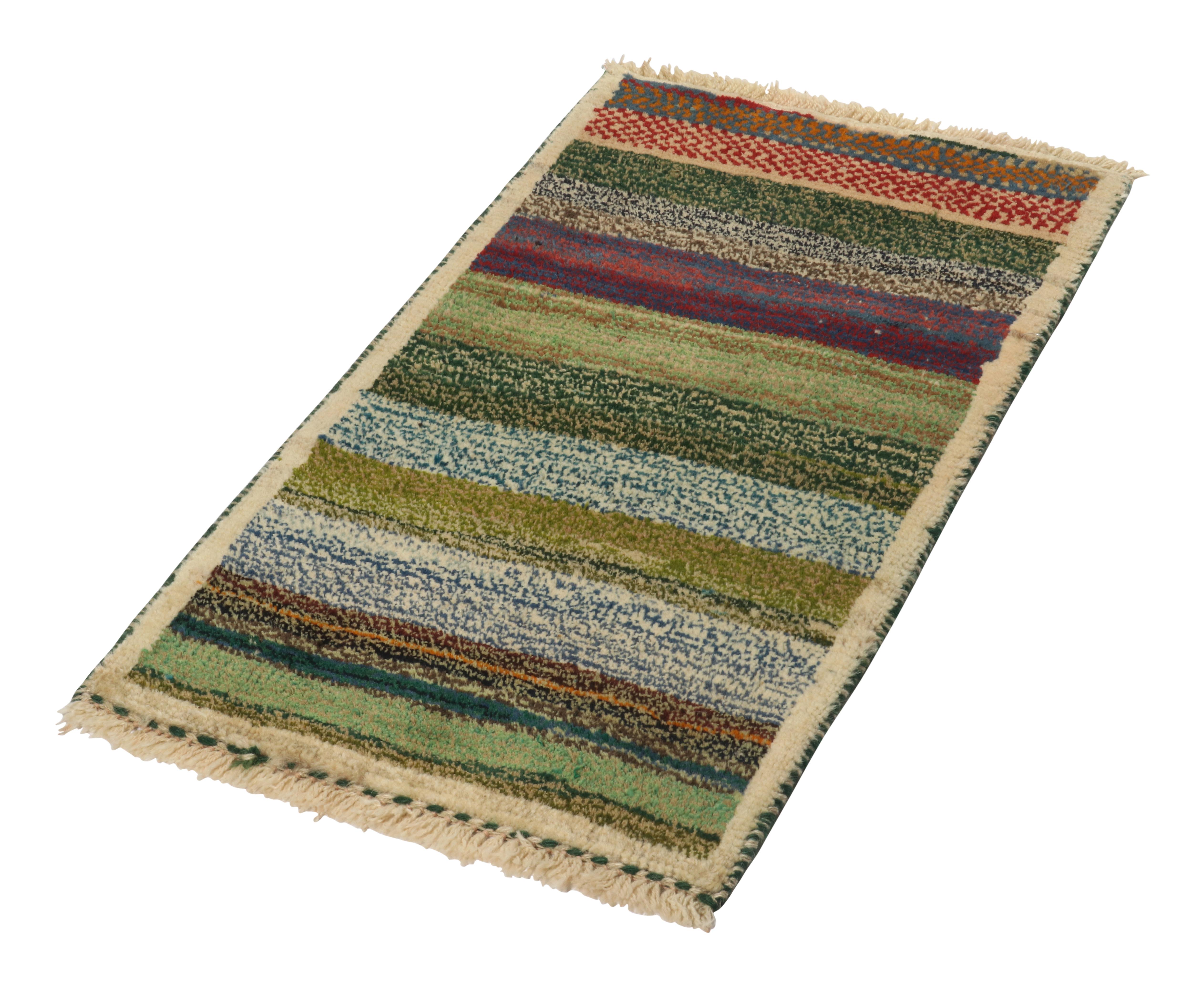 A vintage 2x3 Persian Gabbeh rug of grand entry to Rug & Kilim’s newest curation of rare tribal pieces. Hand-knotted in wool circa 1950-1960. 

On the Design:

This mid-century piece enjoys stripes in green, beige and blue in the more present