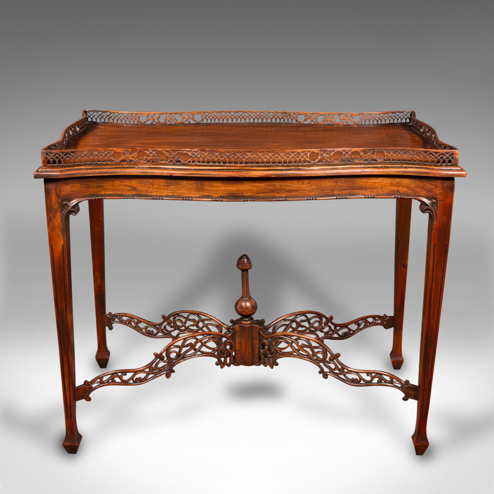 This is a vintage galleried silver table. An English, mahogany ornate table in Chippendale revival taste, dating to the late 20th century, circa 1980.

Striking example of revival furniture, graced with superb fretwork
Displays a desirable aged