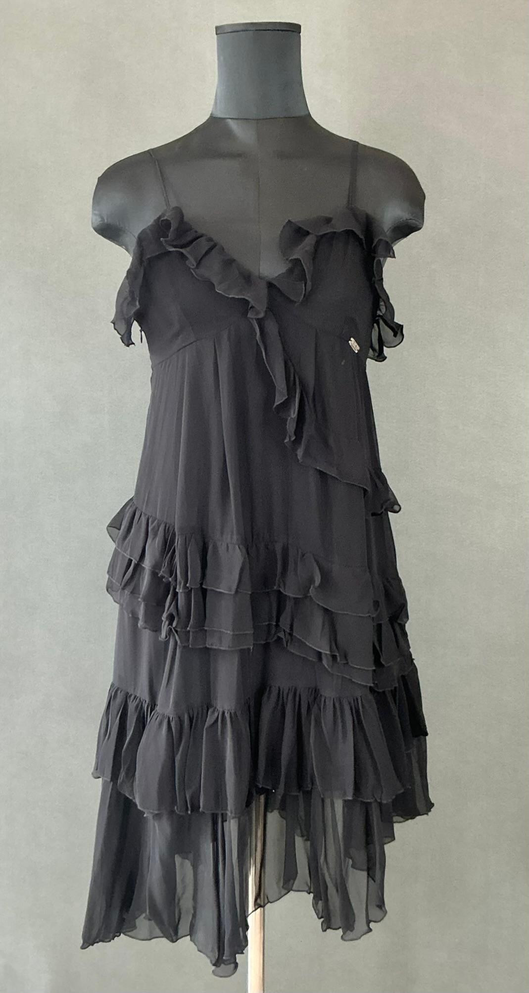 
Un Vestido Vintage Galliano Negro con Volantes es una pieza que encarnaría el estilo dramático y vanguardista por el que es conocido John Galliano. Como diseñador que ha ampliado constantemente los límites de la moda, el trabajo de Galliano