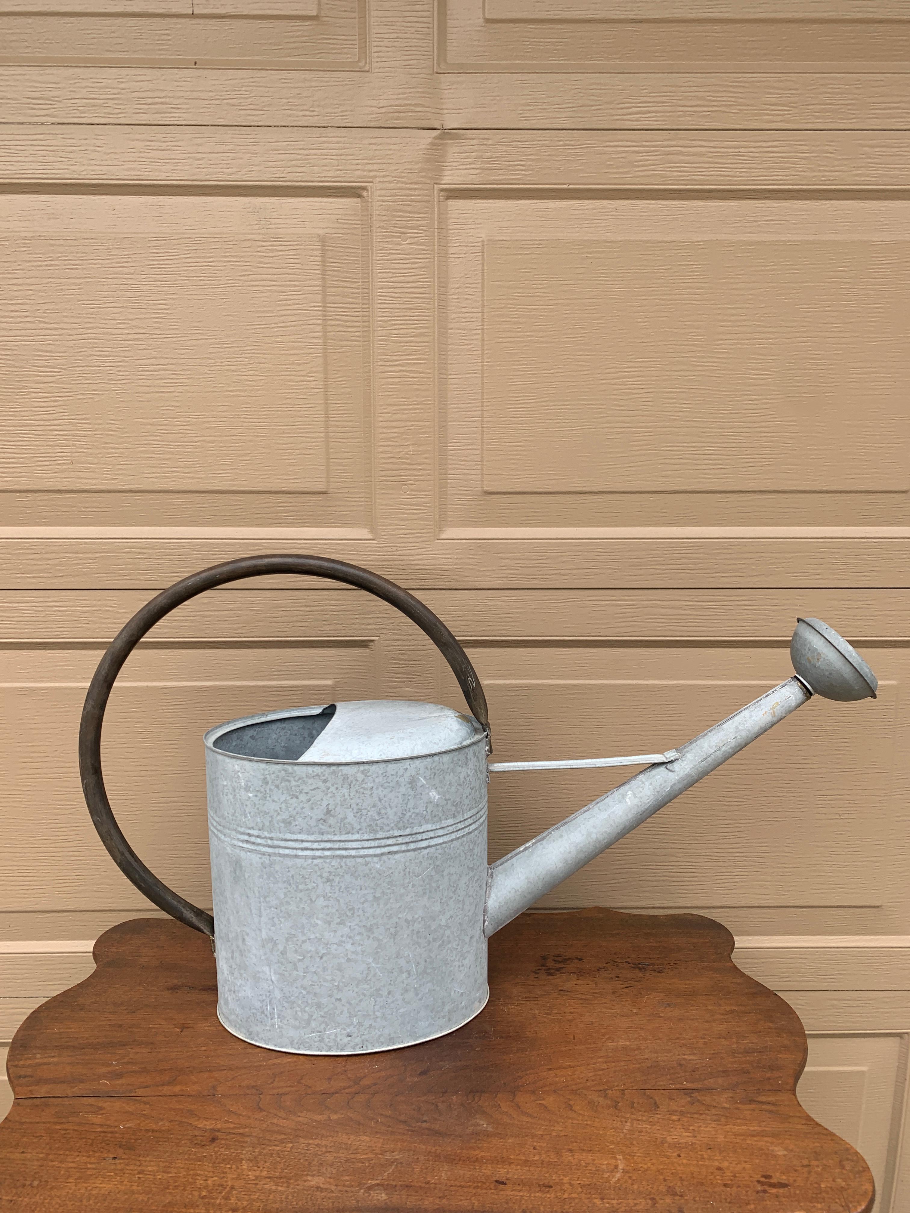 A beautiful vintage galvanized steel garden watering can with a curved copper handle

USA, Circa 1940s

Measures: 29.5