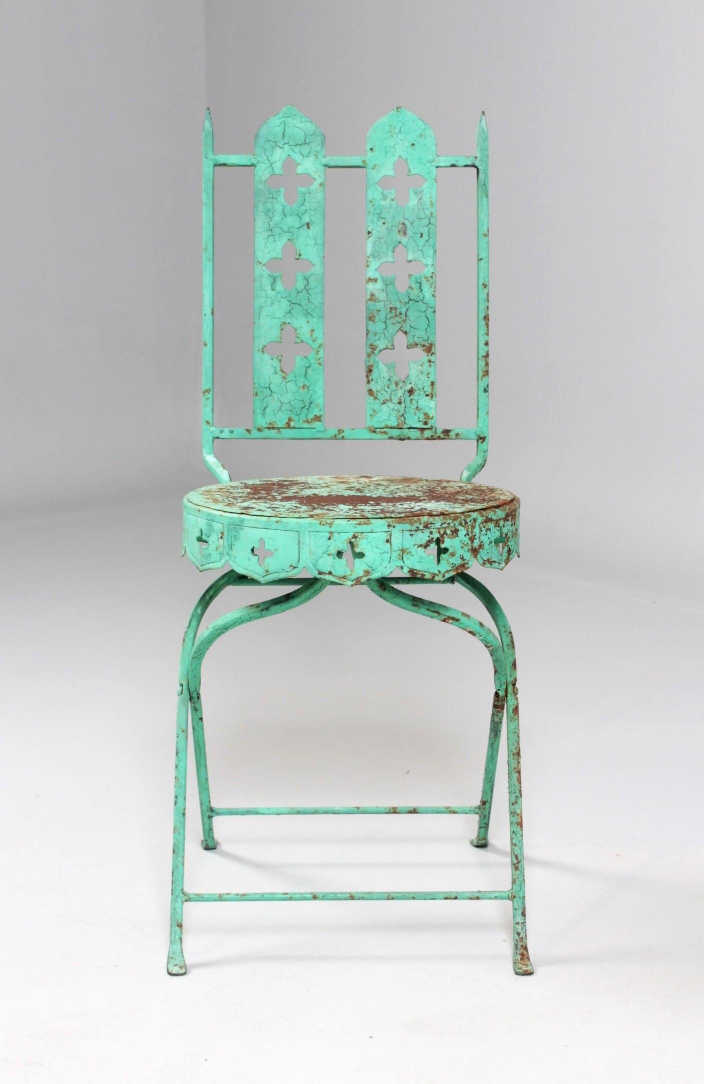Antique or vintage garden chair in neo Gothic style. 
The filigree legs support the round seat with circumferential downward drawn pointed arches and quatrefoils.
The same design style is reflected in the backrest.
In this way, the chair is