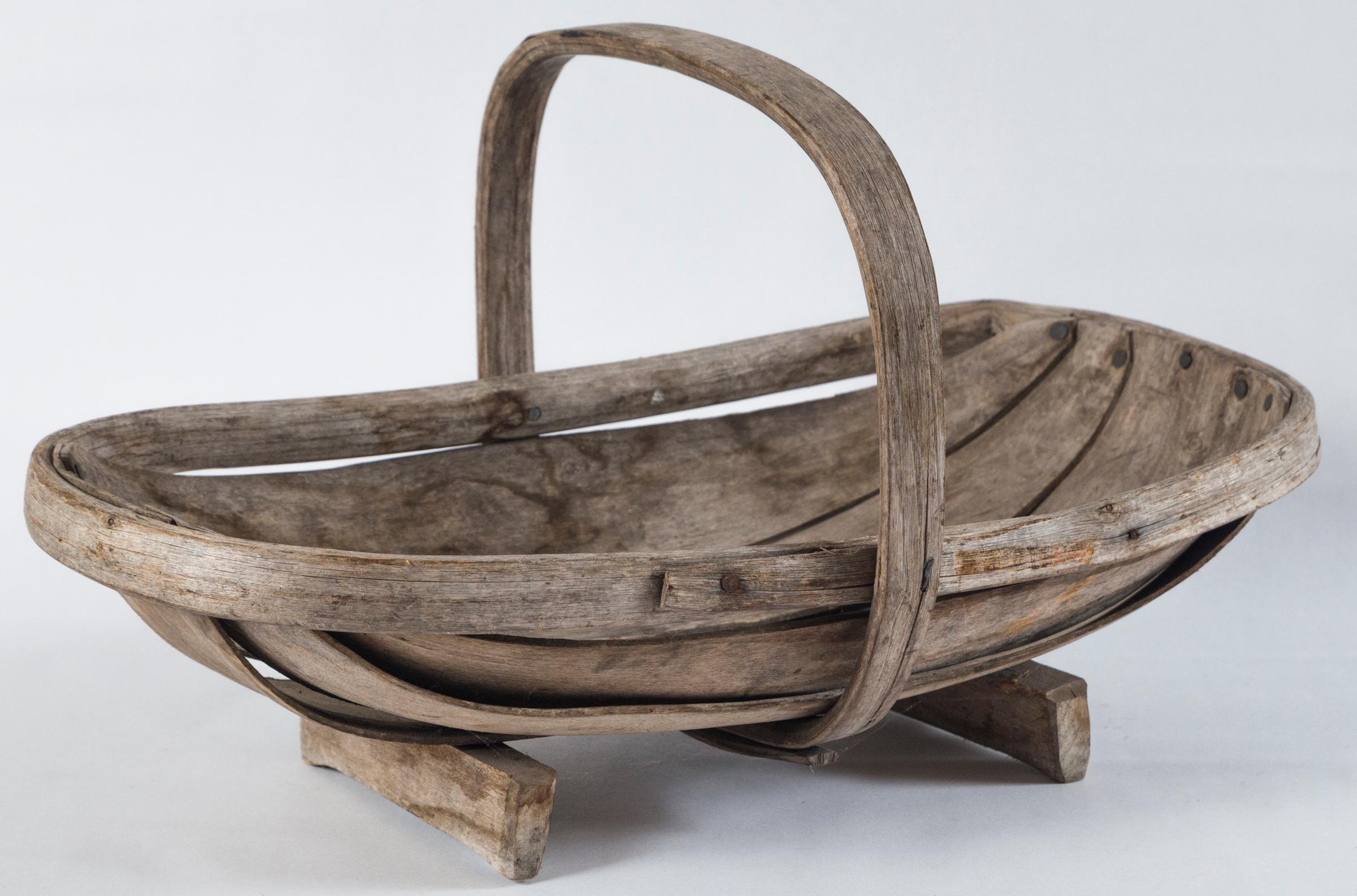 Vintage garden Trug basket, England, circa 1950. Stamped on bottom. Manufactured by The Truggery, Coopers Croft 4, Herstmonseux. The Truggery started manufacturing the Classic Sussex Trug baskets in 1899. Lovely aged patina.