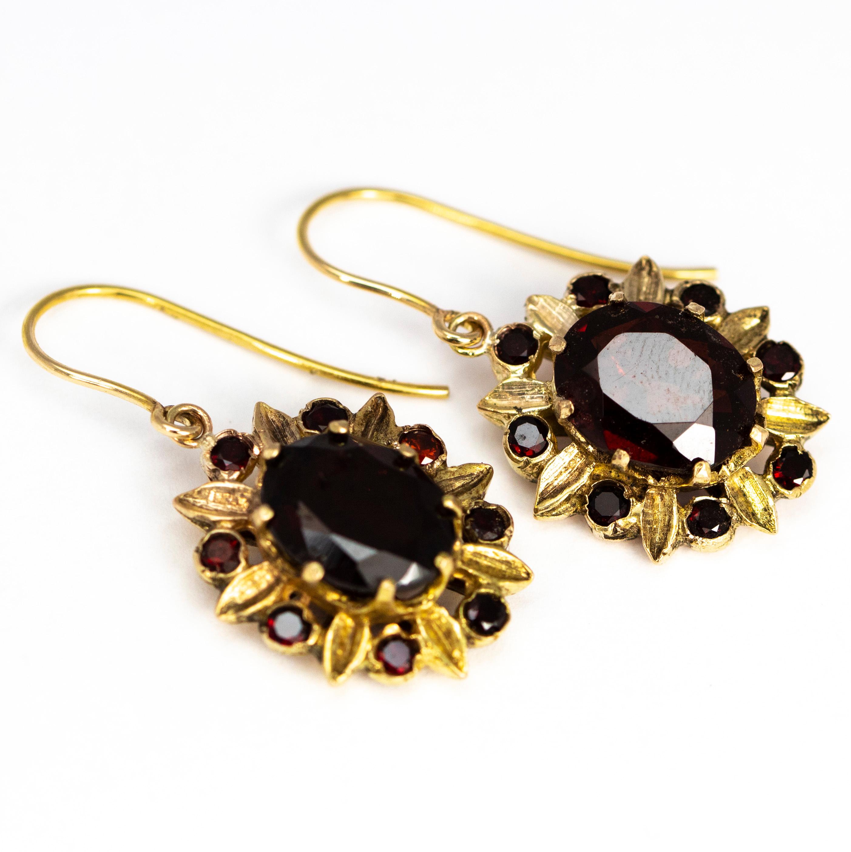 These gorgeous earrings hold a large garnet at the centre of a floral style cluster which holds smaller garnets and small leaf type gold details around the edge. 

Centre stone: 10.5mm 
From Ear To Bottom Of Drop: 30mm 

Weight: 6.43g