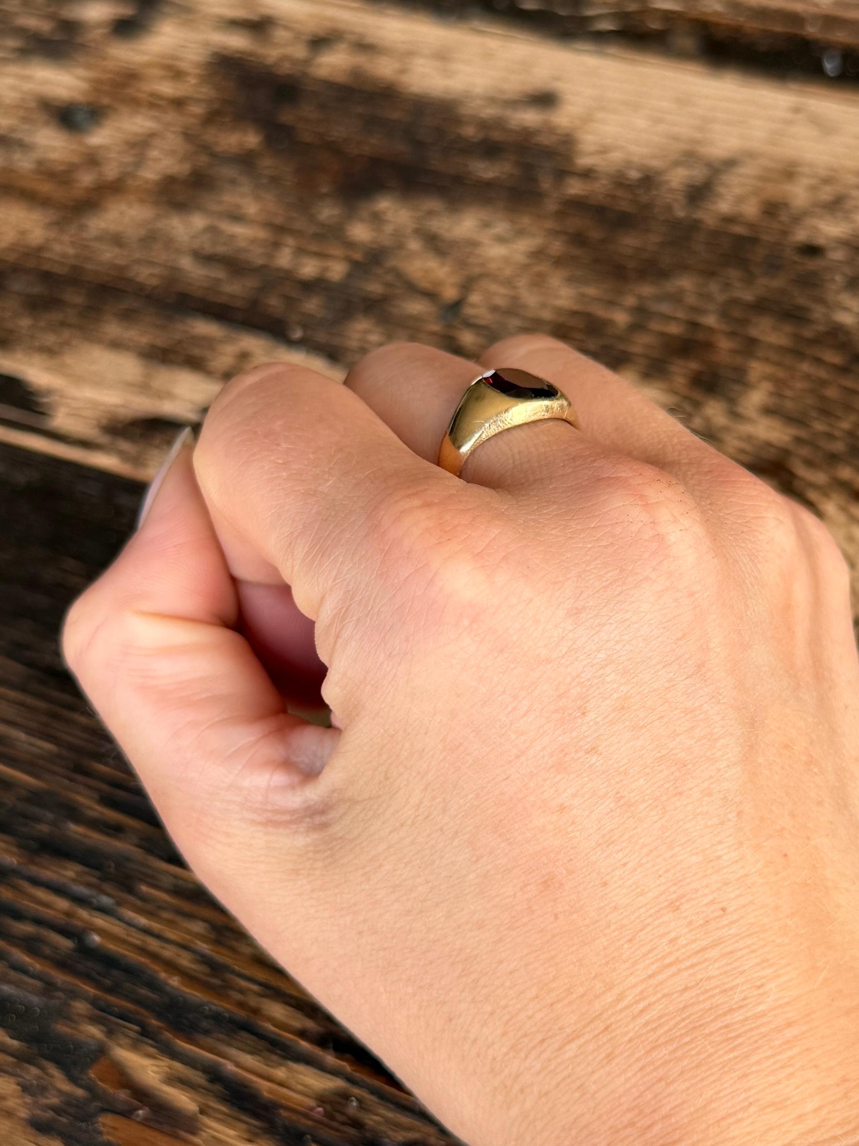Questo anello con sigillo dallo stile semplice contiene una pietra di granato.  Marchio Chetser e modello in oro 18 carati. 

Misura dell'anello: N o 6 3/4
Dimensioni della pietra: 9x8 mm

Peso: 5,1 g
