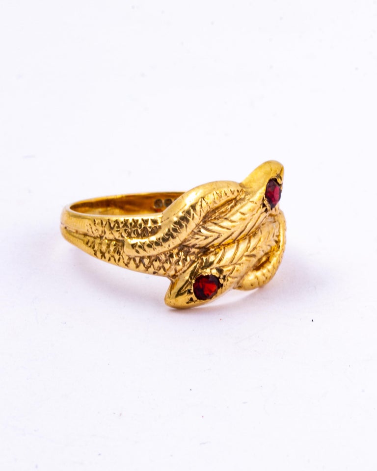 This stunning ring featured two snakes that are wrapped around each other to create this ring. The serpents have a round cut garnets on top of each of their heads. Modelled in 9ct gold and made in Birmingham, England.  

Ring Size: Y or 10
Width At