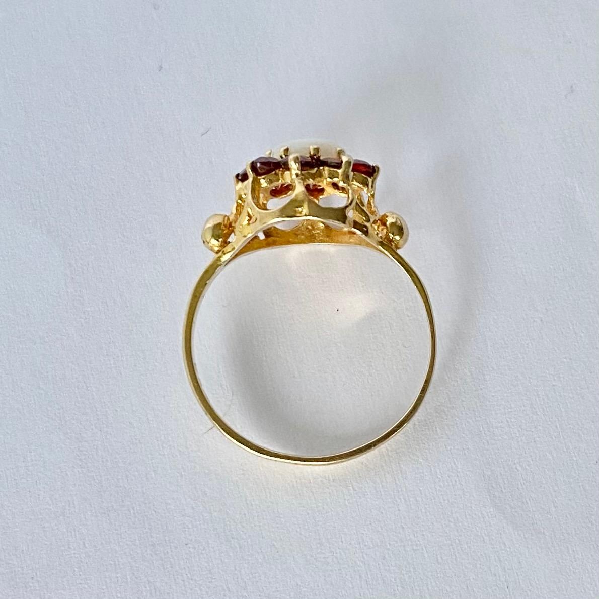 This striking ring holds round cut garnets totalling approx 60pts and a shimmering opal at the centre. All the stones sit in open 9carat gold claws. 

Ring Size: N or 6 3/4 
Cluster Diameter: 11mm
Height Off Finger: 7mm

Weight: 1.8g