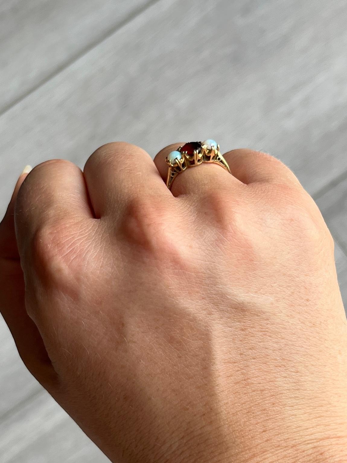 Either side of the deep red garnet are two shimmering opals. The garnet measures 50pts. Modelled in 9 Carat gold. Hallmarked Birmingham 1963.

Ring Size: M 1/2 or 6 1/2 
Height off finger: 5mm

Weight: 2.2g 