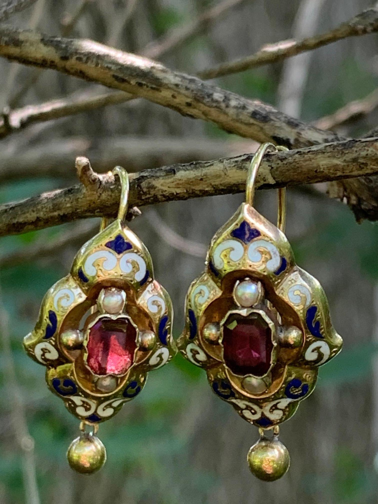 Well, these earrings are quite the beauties.  The center stone is an emerald cut garnet.  There are two small pearls place at the top and bottom of the center stone.  Each earring has a gold ball dangling nicely from the main part of the earring. 