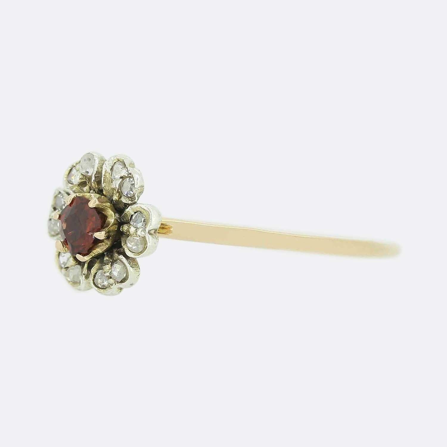 Here we a lovely vintage flower ring. The head of the piece has been crafted into a shape replicating a buttercup and showcases a round claw set garnet at the centre with the six pairs of rose cut diamonds being set around the outer edge acting as