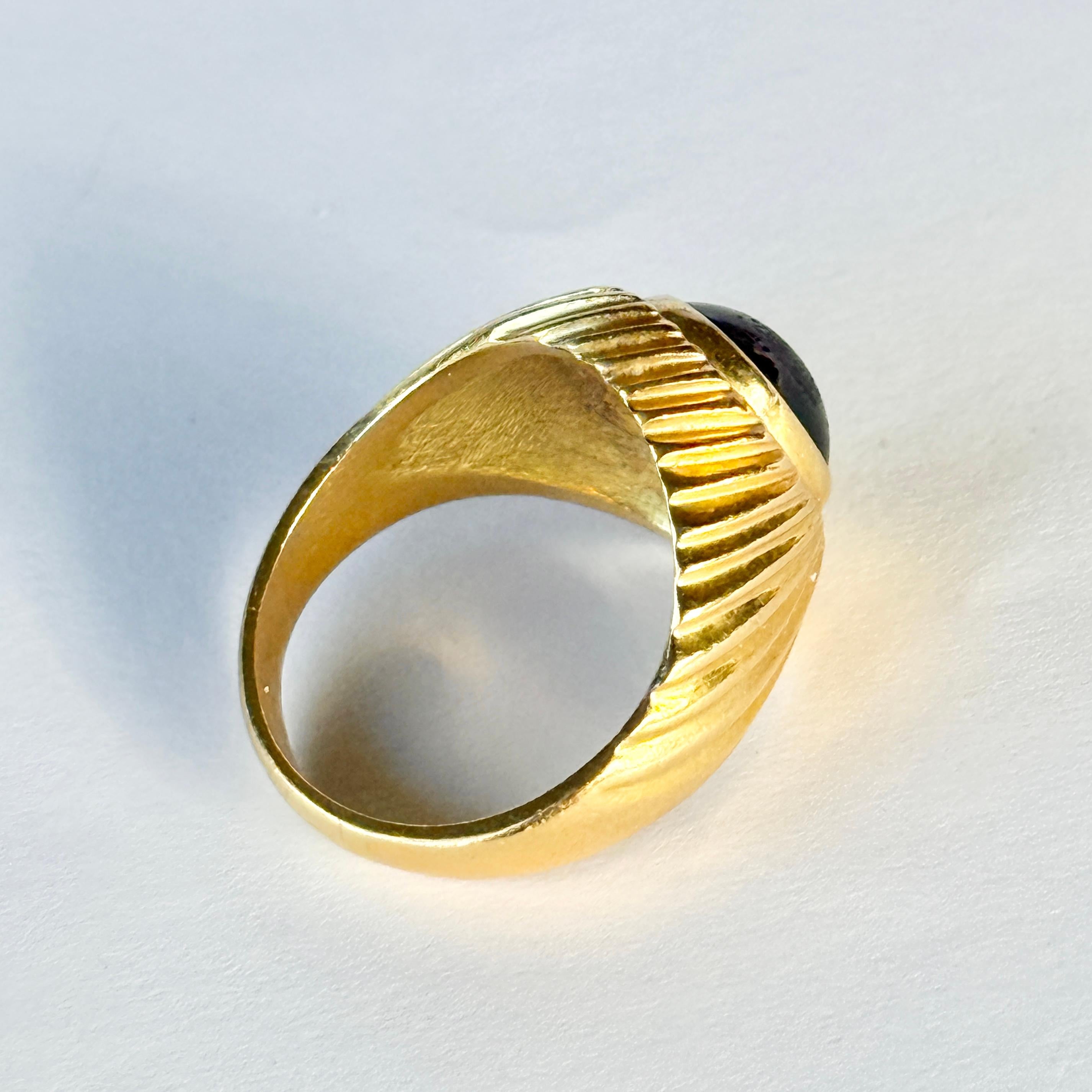 Su una splendida fascia in oro giallo 9 carati lucido si trova una pietra cabochon di granato altrettanto lucida. La pietra si estende per quasi tutta la larghezza dell'anello. 

Misura dell'anello: M 1/2 o 6 1/2 
Dimensioni della pietra: 10x8