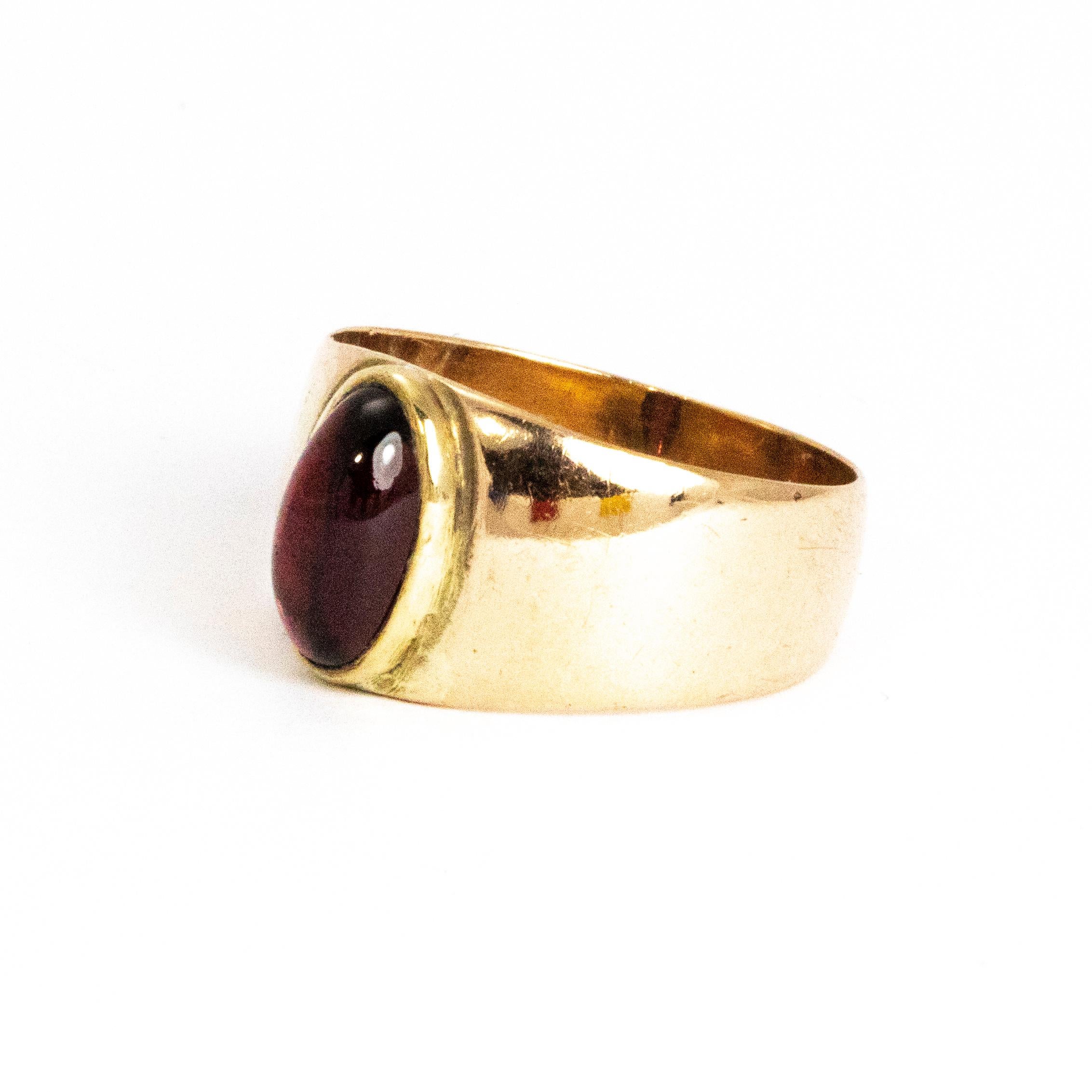 This glossy oval garnet cabochon is held in a grooved setting on a chunky 9ct gold band. The band is wide by quite slim in thickness making it very comfortable to wear.

Ring Size: M or 6 1/4 
Band Width: 5mm 