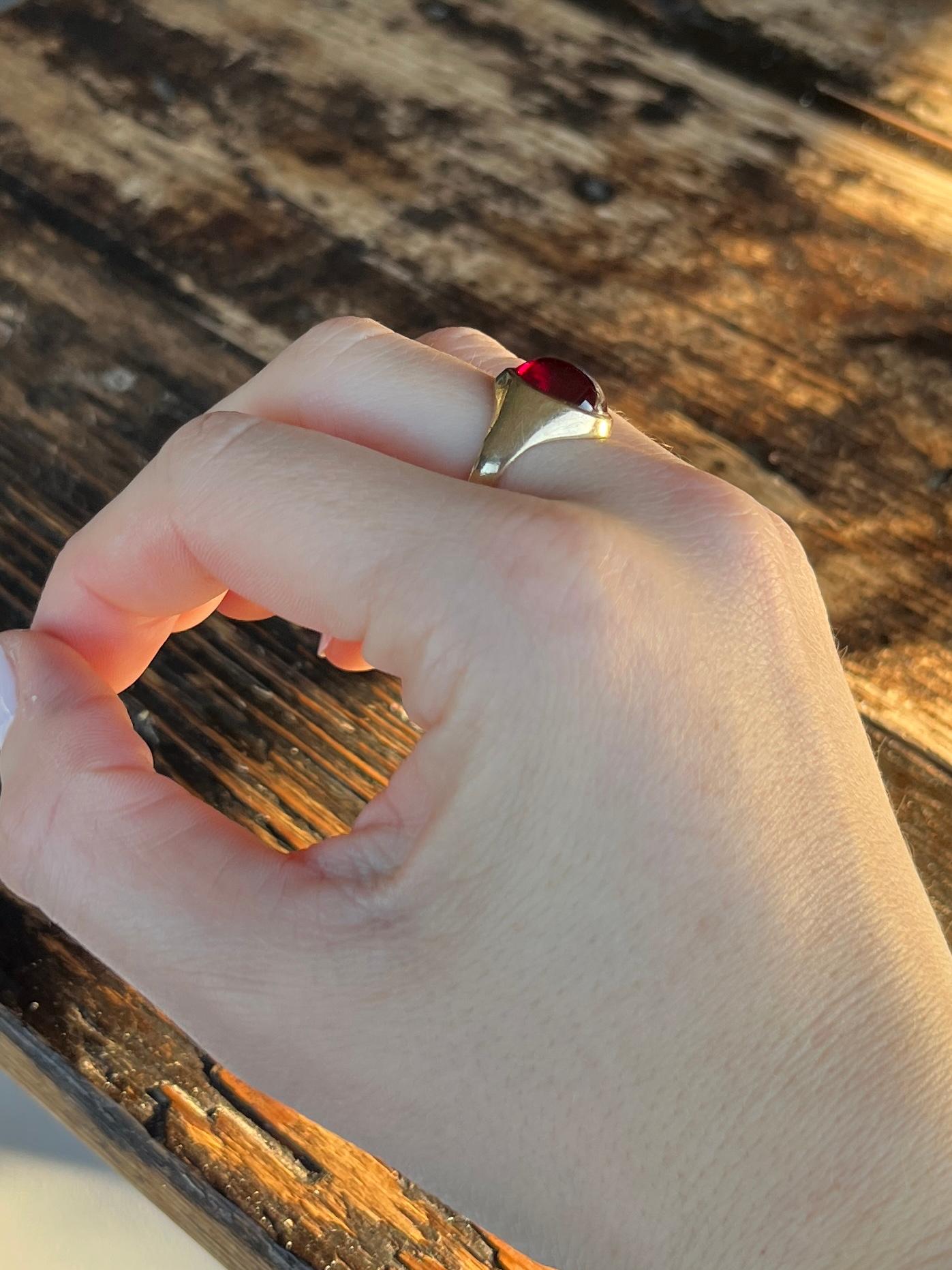 Sat proud upon a gorgeous glossy 9ct yellow gold band is an equally glossy garnet cabochon stone. The stone nearly spans the whole width of this ring. Made in London 1965, England.

Ring Size: M or 6 1/4 
Stone Dimensions: 12x10mm

Weight: 4.3g